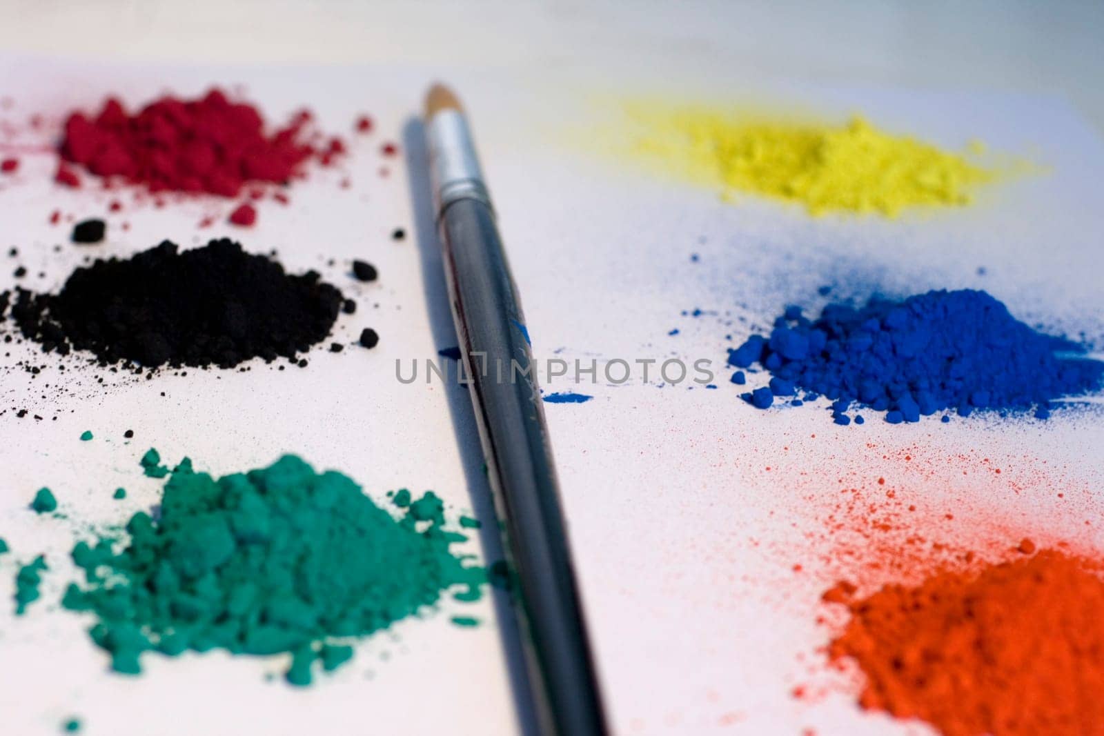 Various pigments colors and brush on a white backround