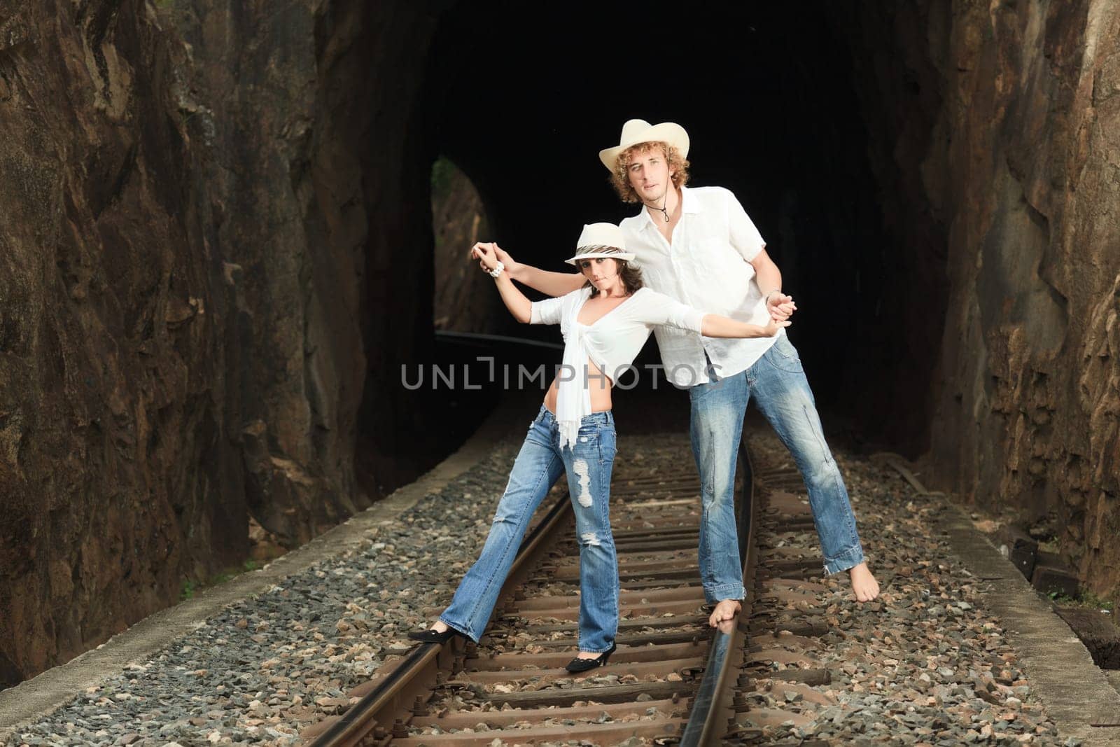 Young couple posing on a train tracks