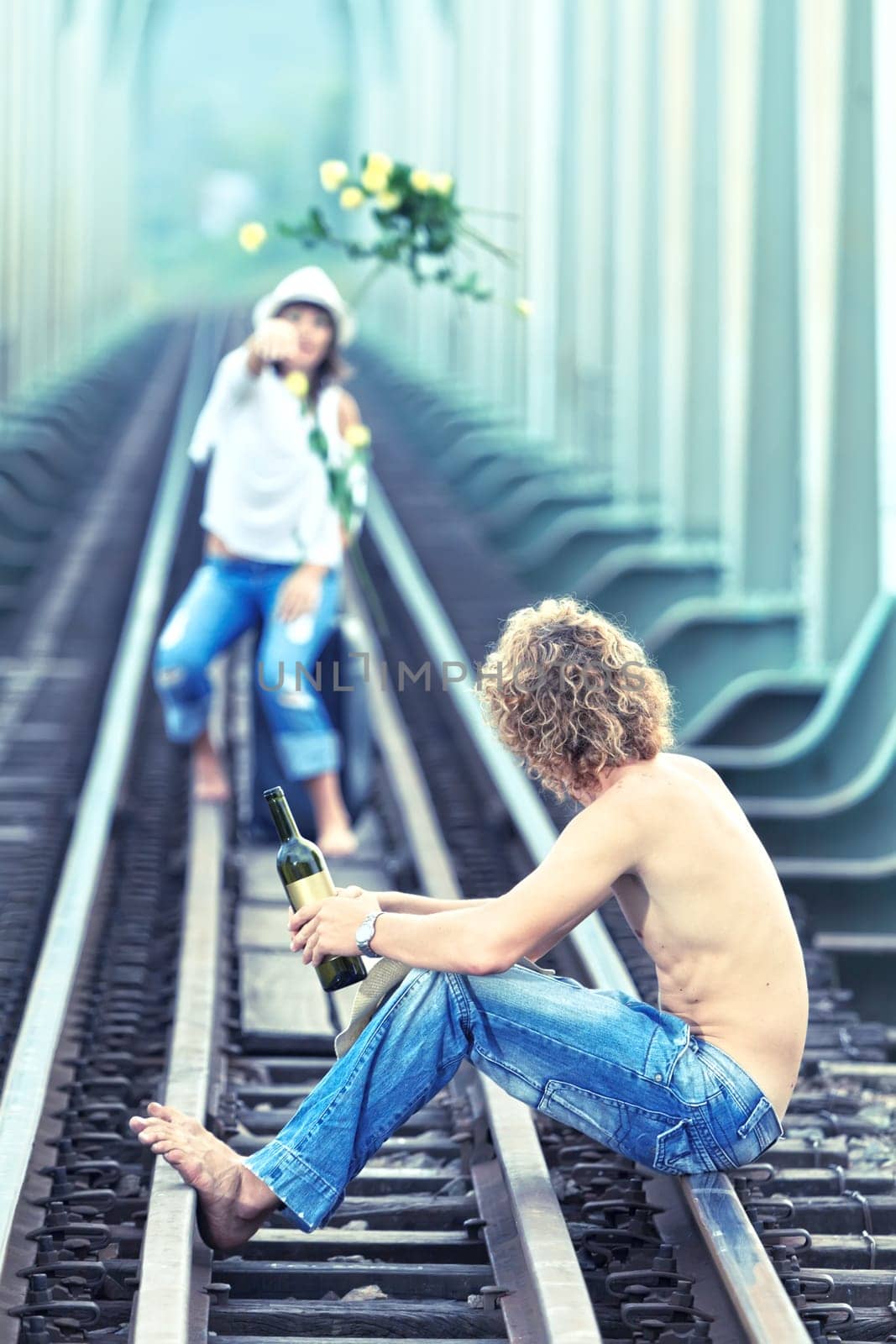 Young woman throwing flowers on train tracks