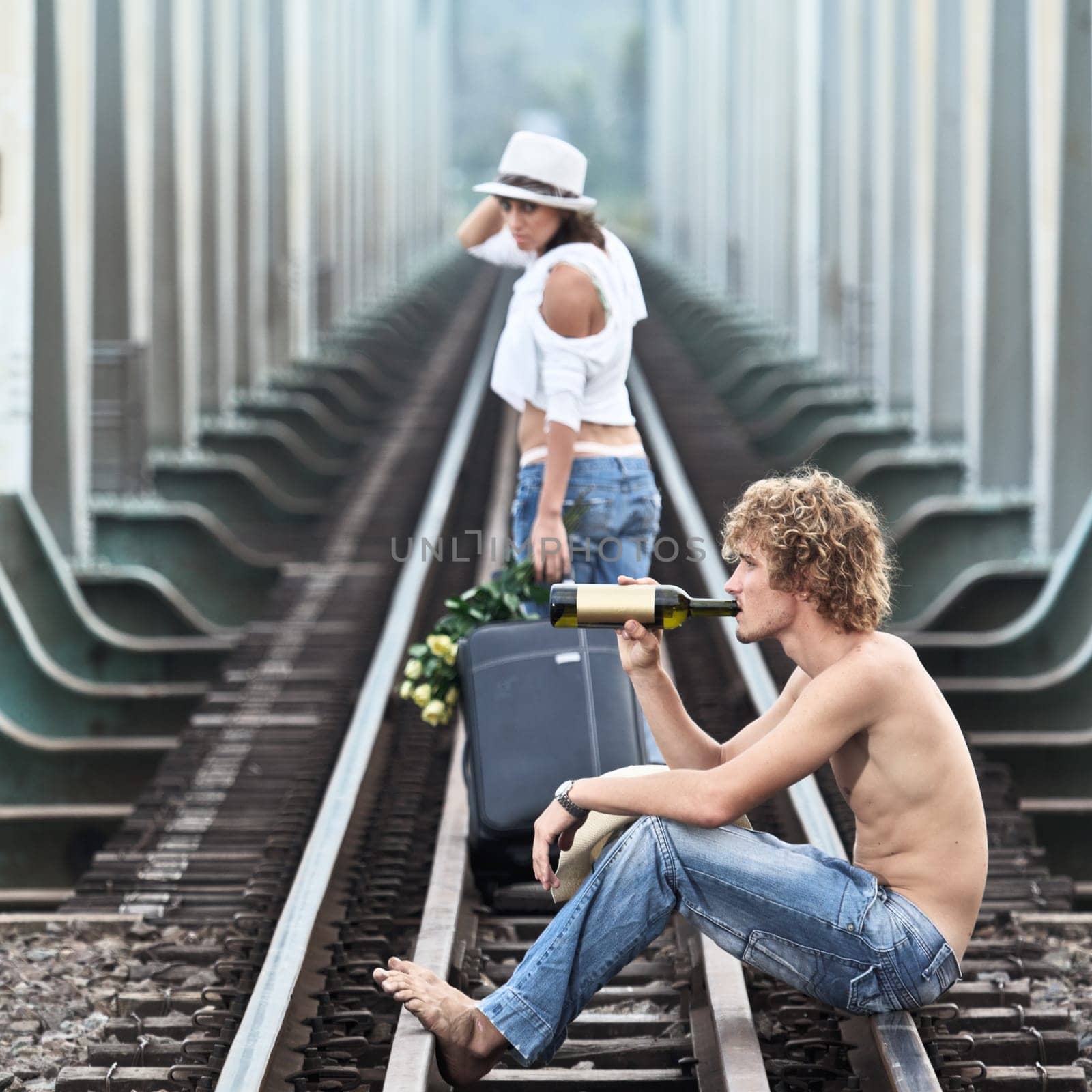 Young woman leaving men on a train tracks