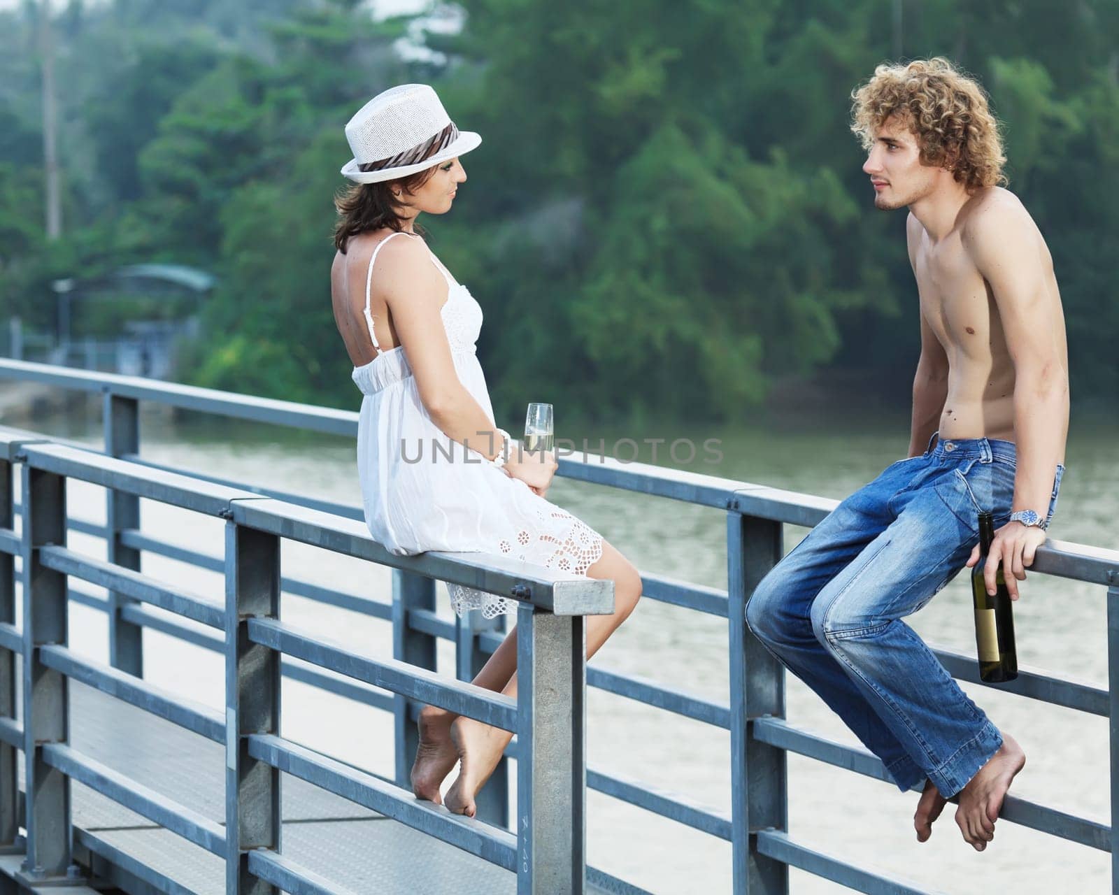 Young couple drinking on a bridge