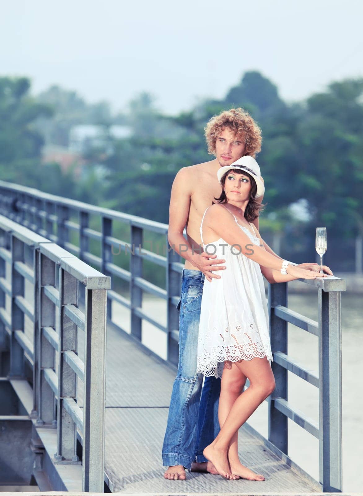 Young couple drinking on a bridge