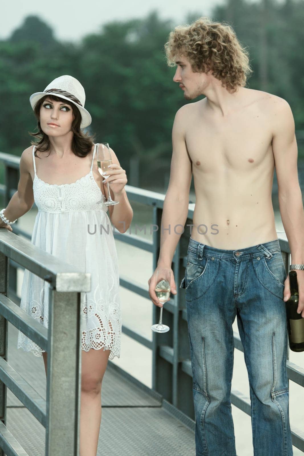 Young couple drinking on a bridge