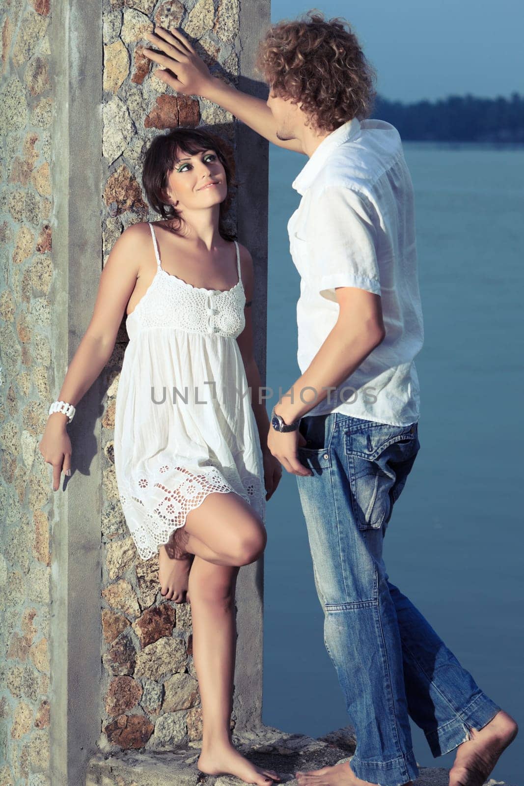 Young couple near the river at twilight time