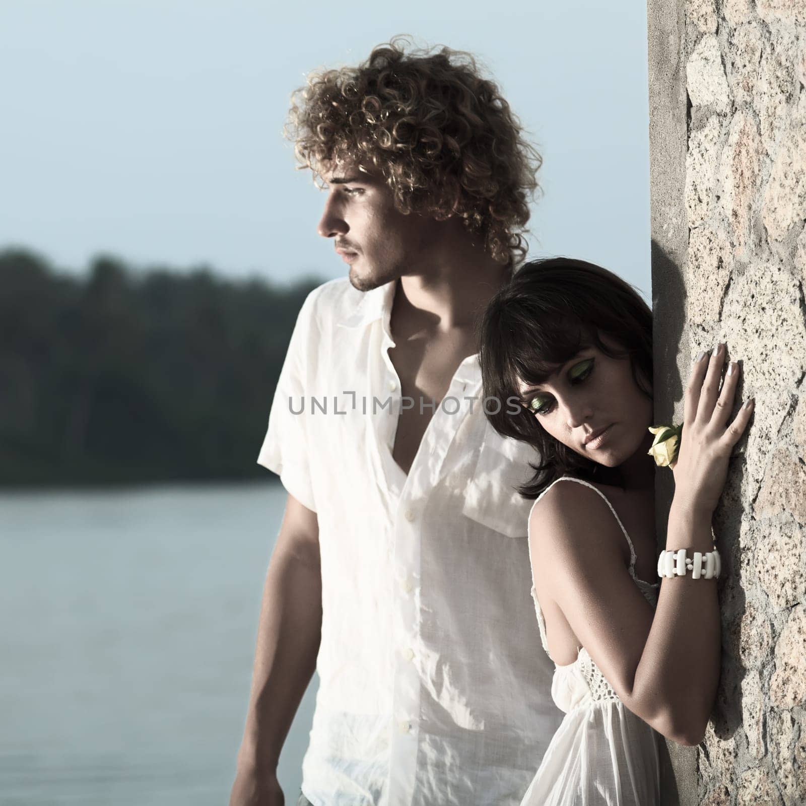 Young couple near the river at twilight time