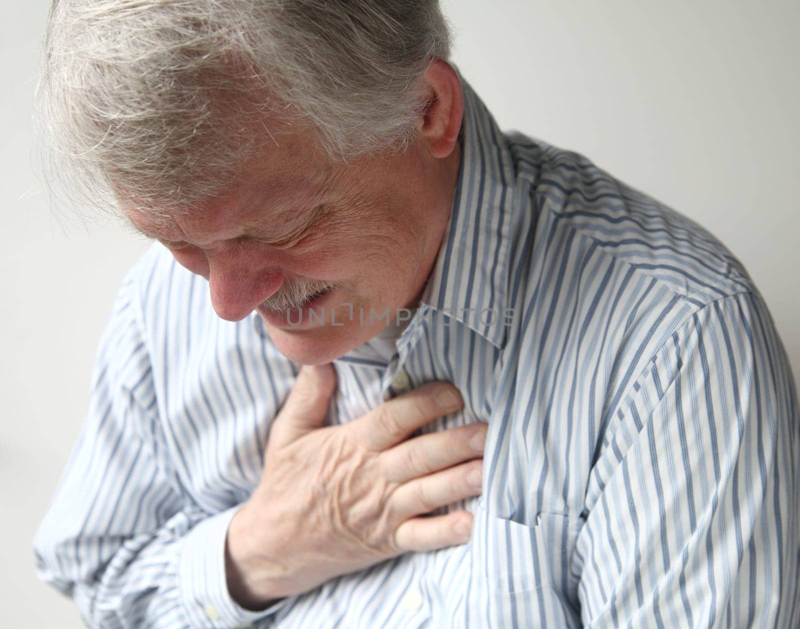 a senior man suffering from bad pain in his chest