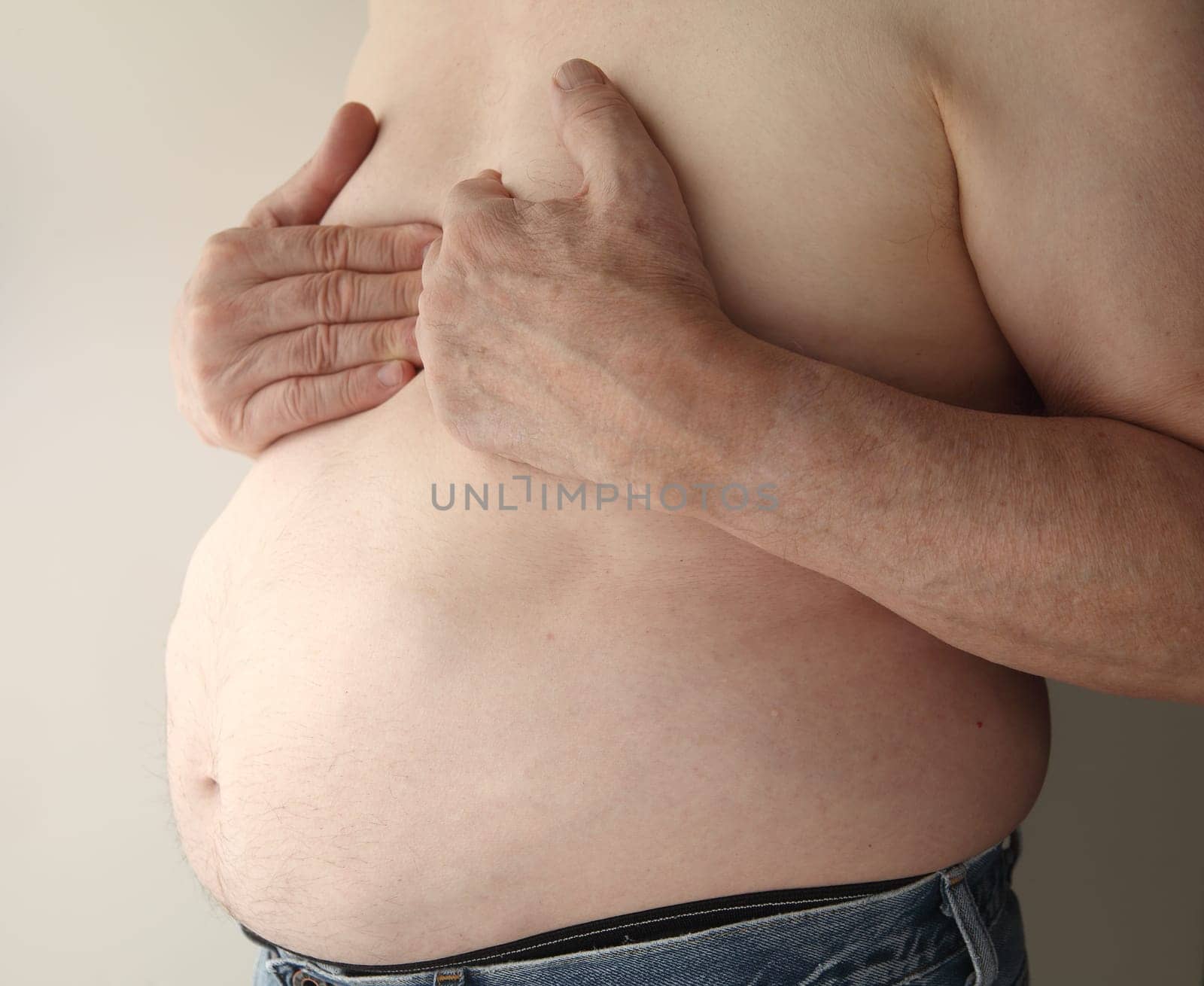 shirtless, overweight man with heartburn or possibly more serious chest pain