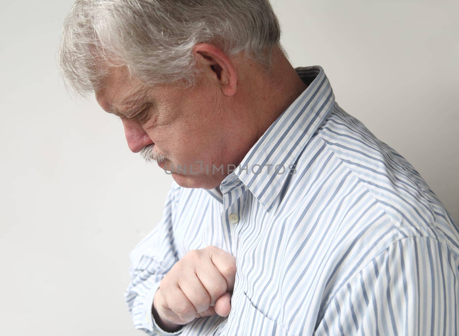 businessman with chest discomfort that could be either heartburn or a heart attack
