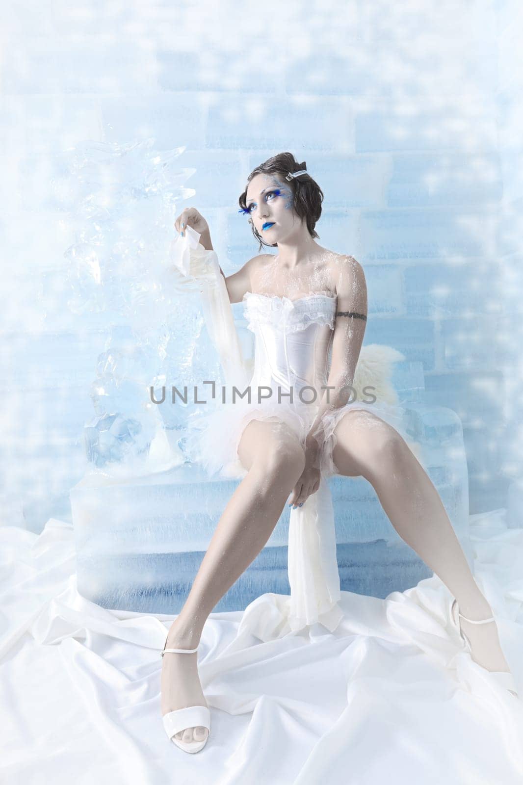 Woman as a snow queen in ice room