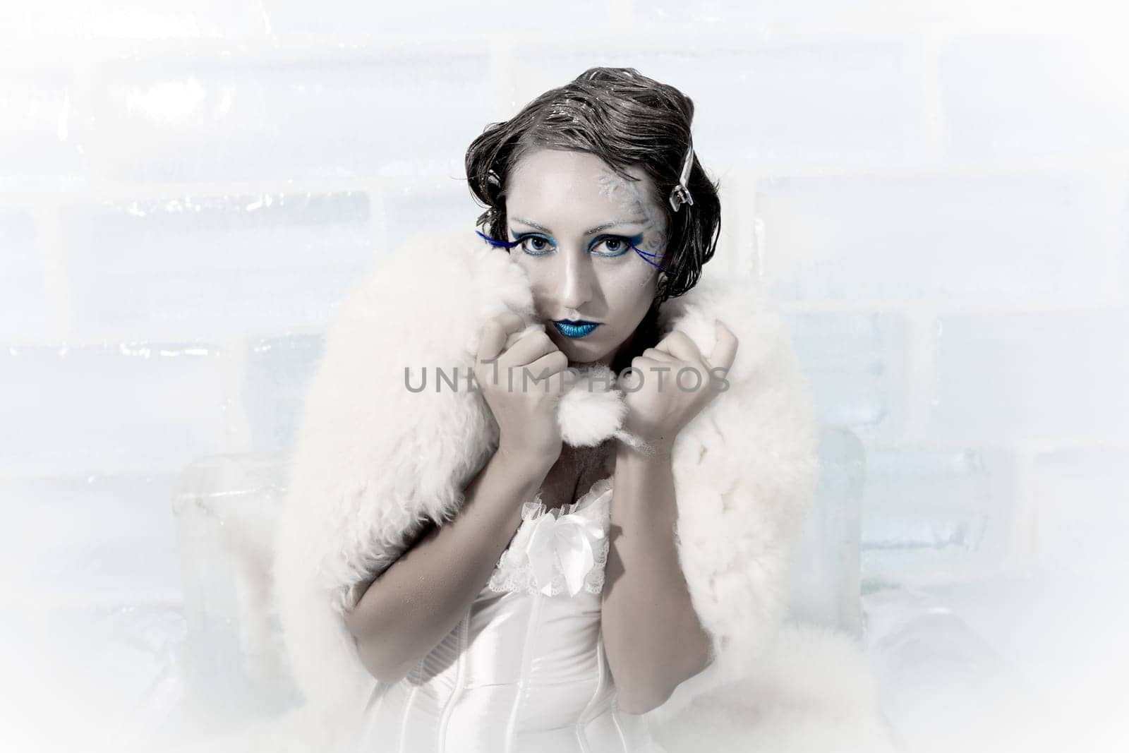 Woman as a snow queen in ice room