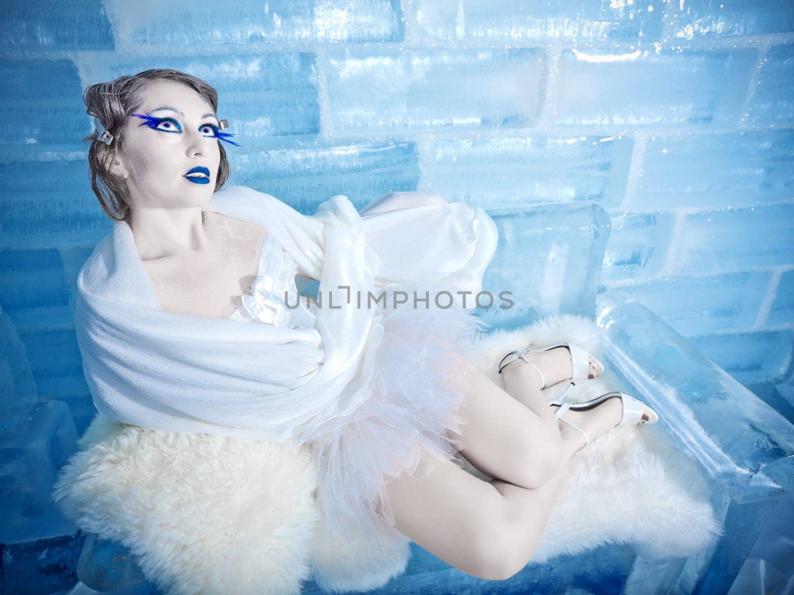 Woman as a snow queen in ice room