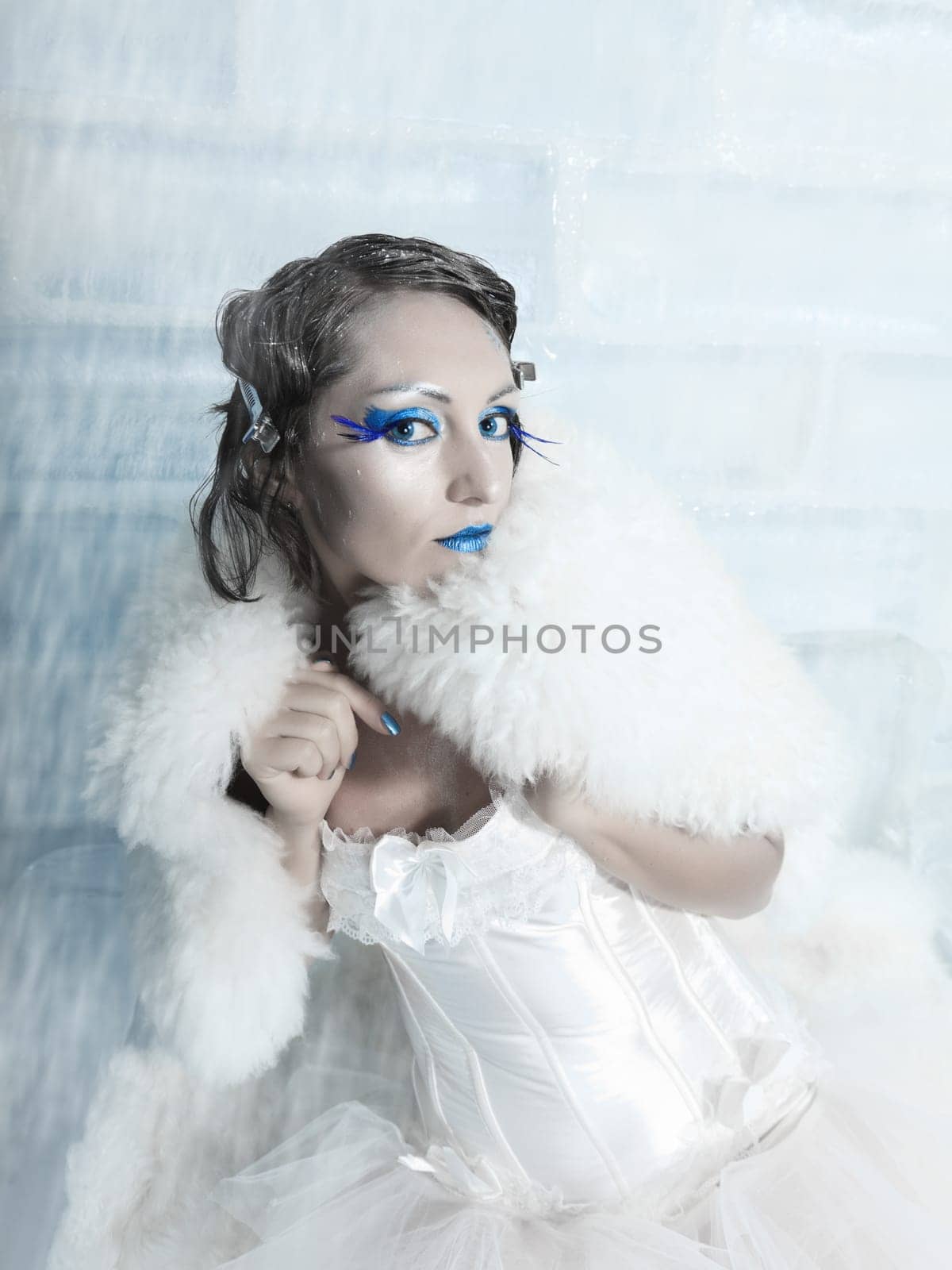 Woman as a snow queen in ice room