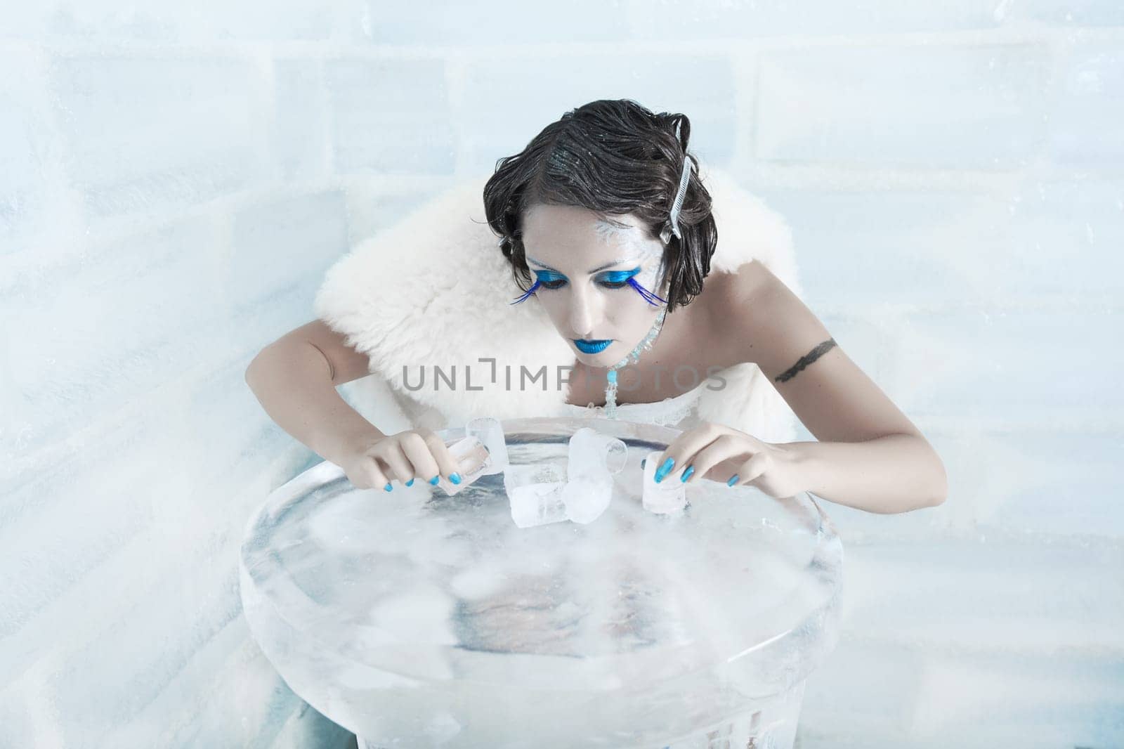 Woman as a snow queen in ice room