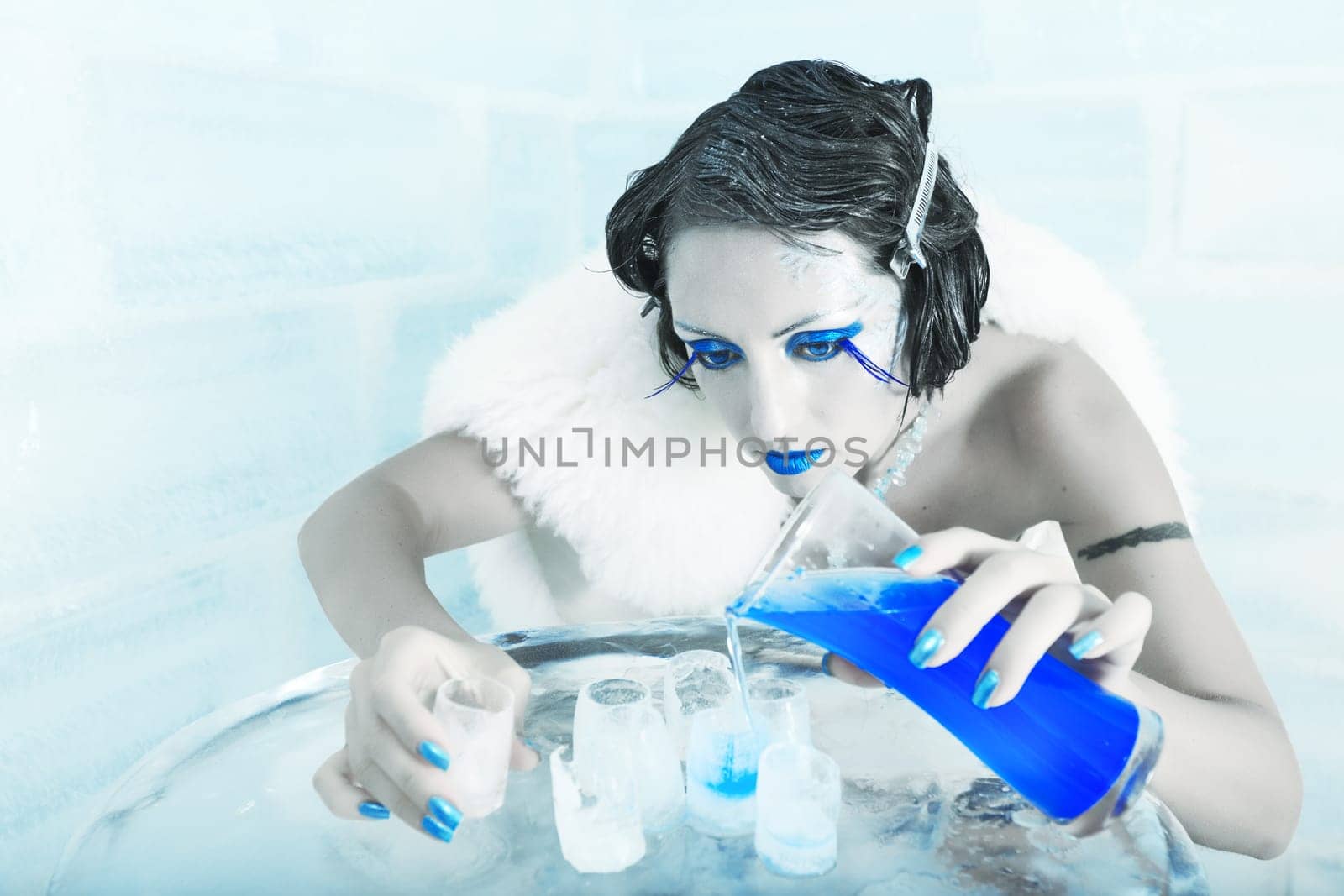 Woman as a snow queen in ice room