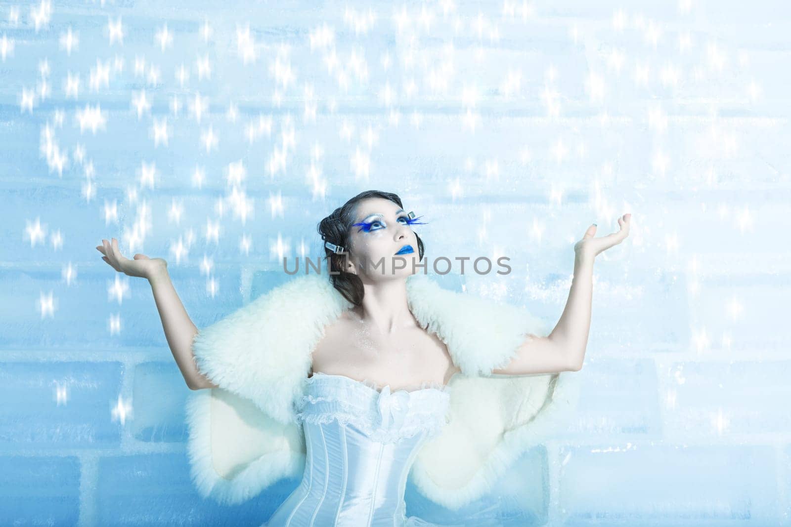 Christmas woman as a snow queen in ice room