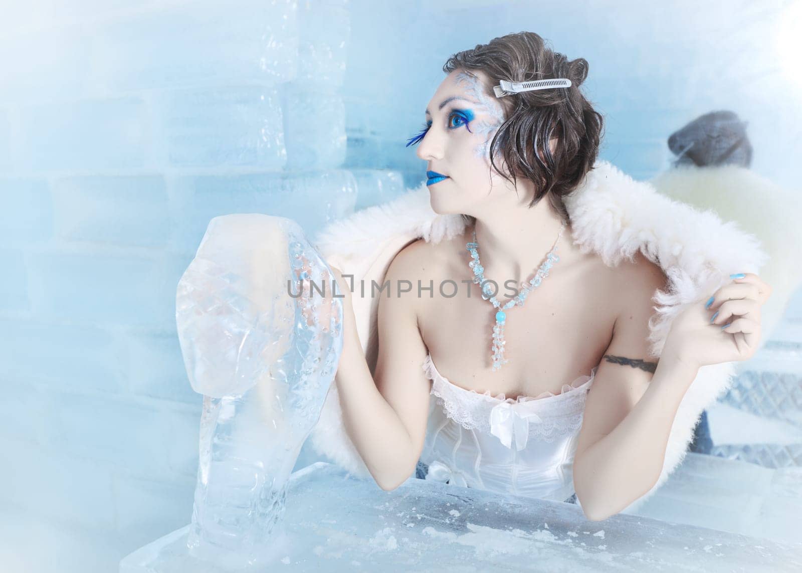 Woman as a snow queen in ice room