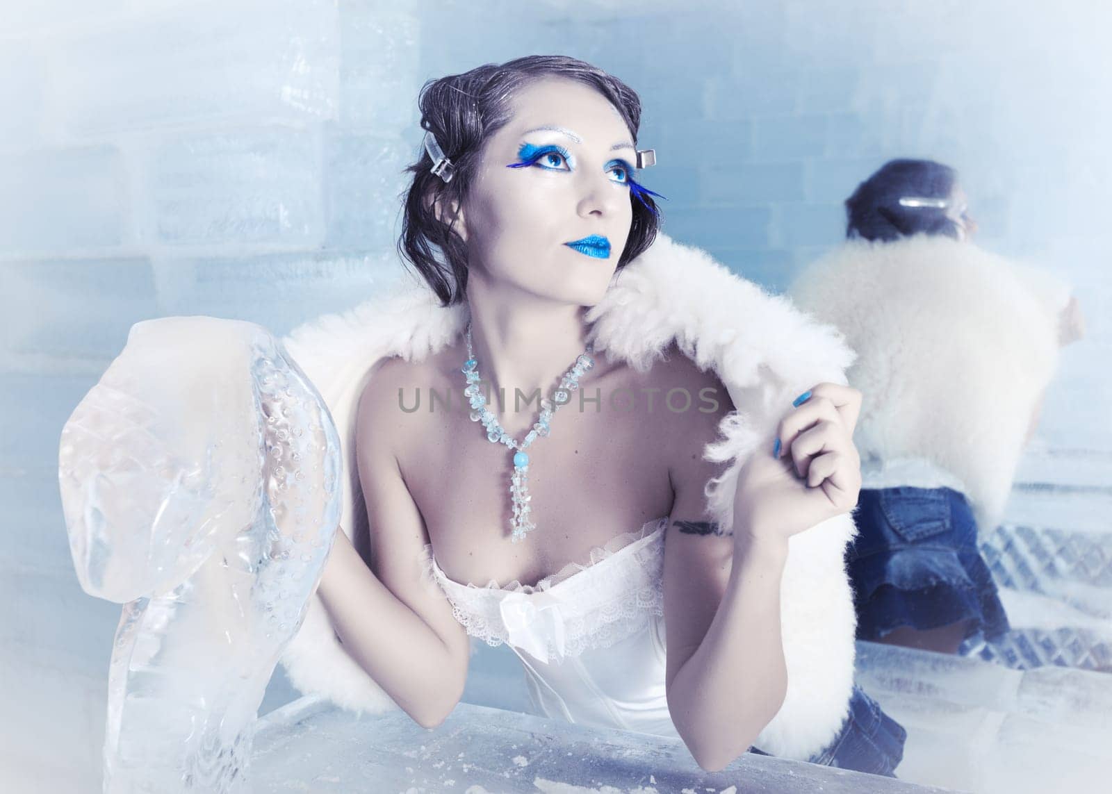 Woman as a snow queen in ice room