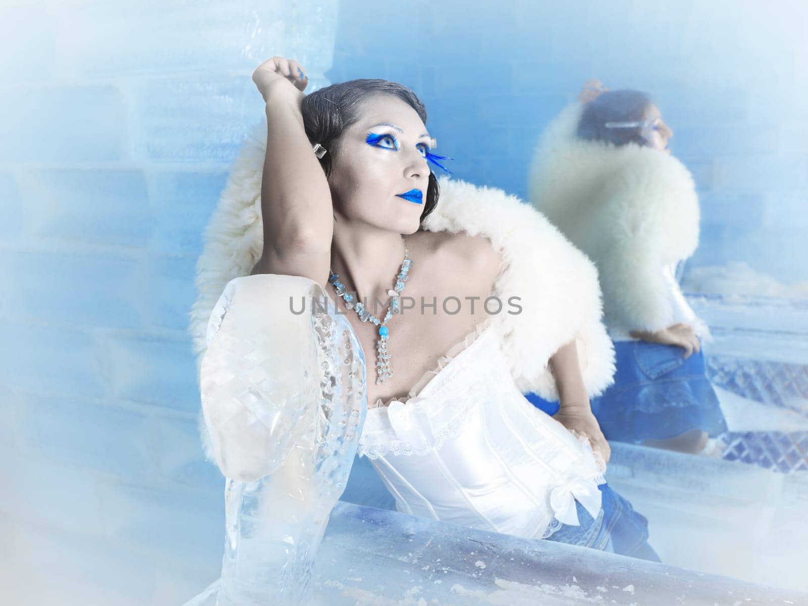 Woman as a snow queen in ice room