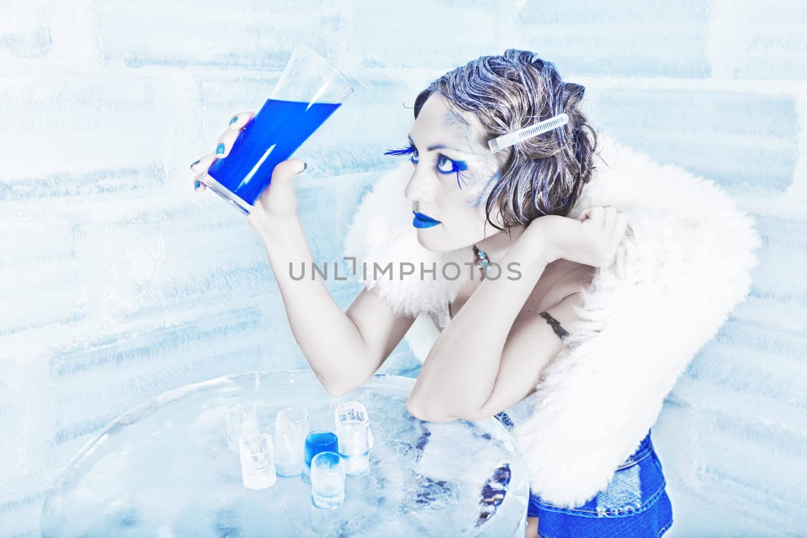 Woman as a snow queen in ice room