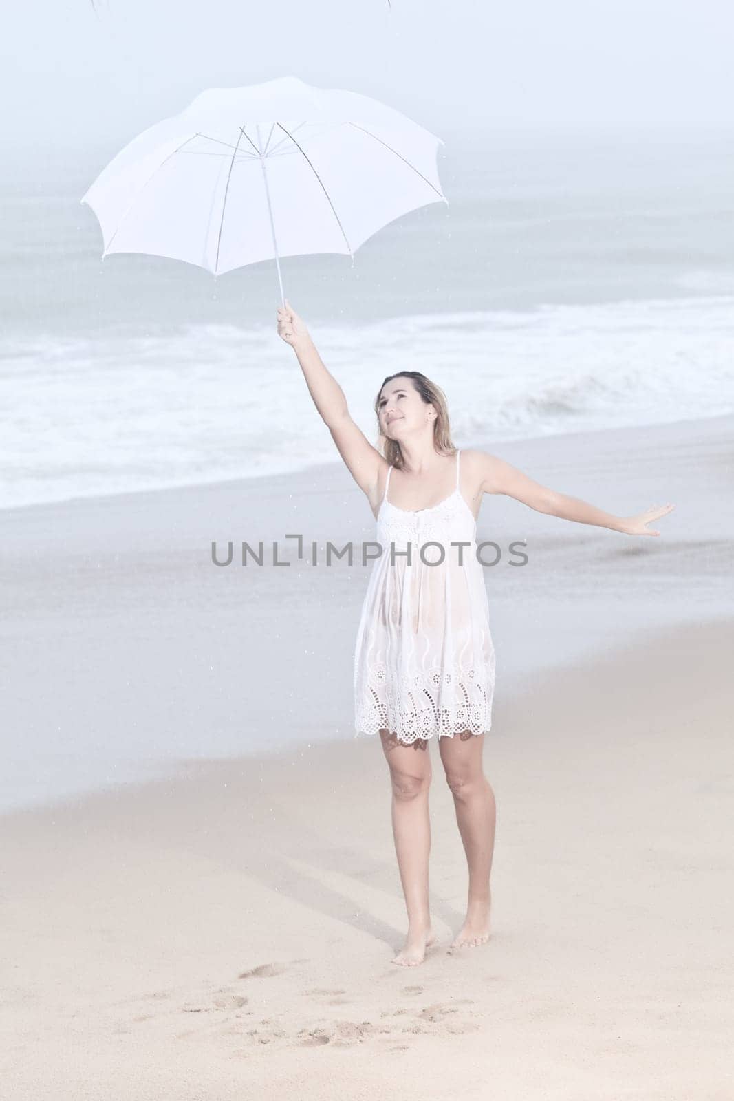 Beautiful woman near the stormy ocean at rain