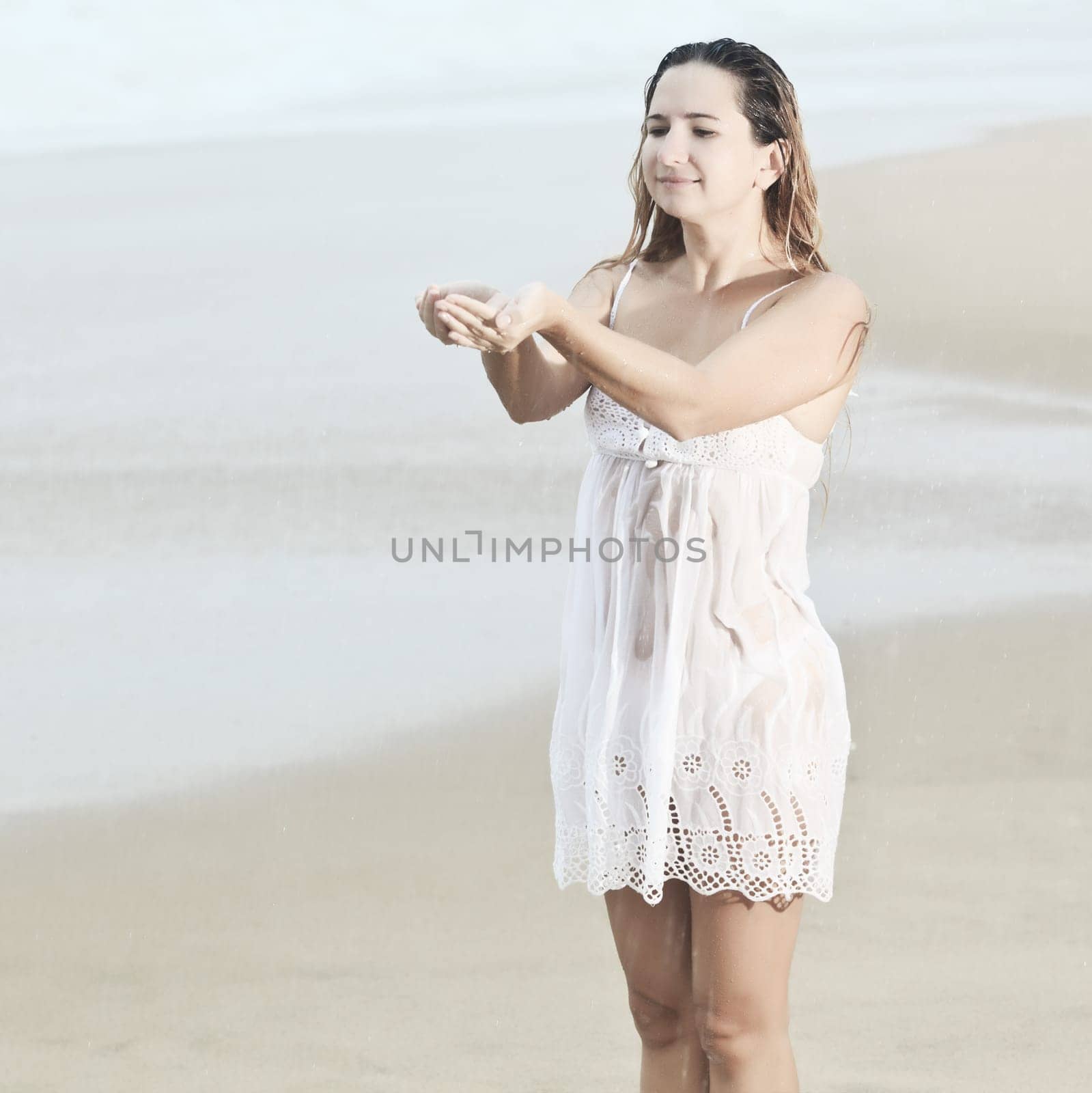 Beautiful woman near the stormy ocean at rain