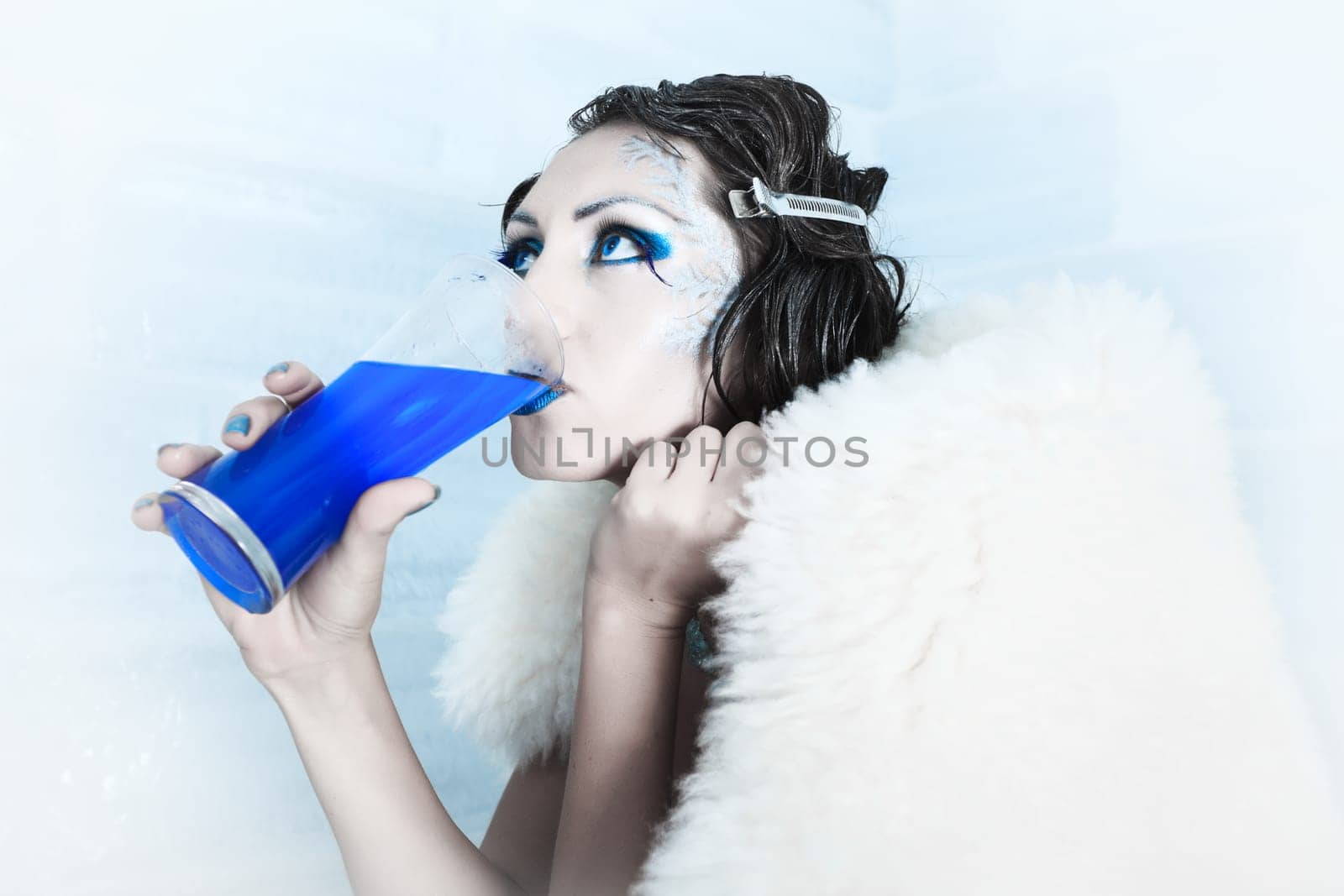 Woman as a snow queen in ice room