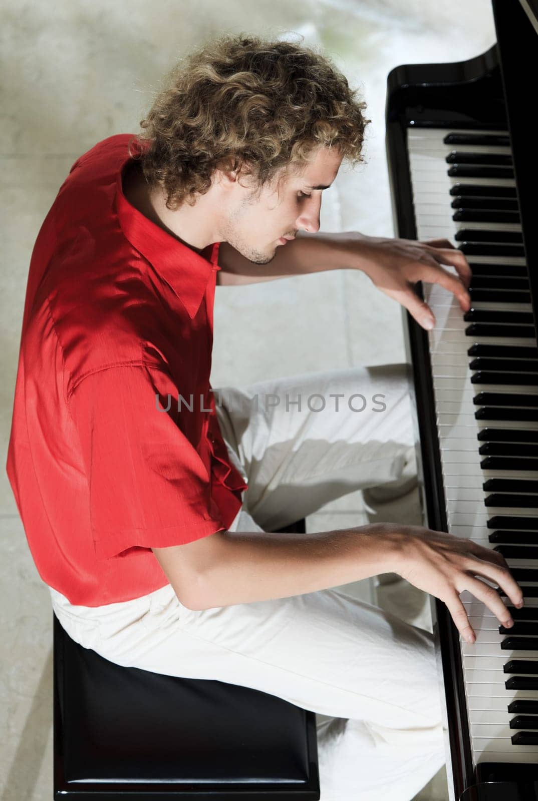 Handsome young man playing on the piano