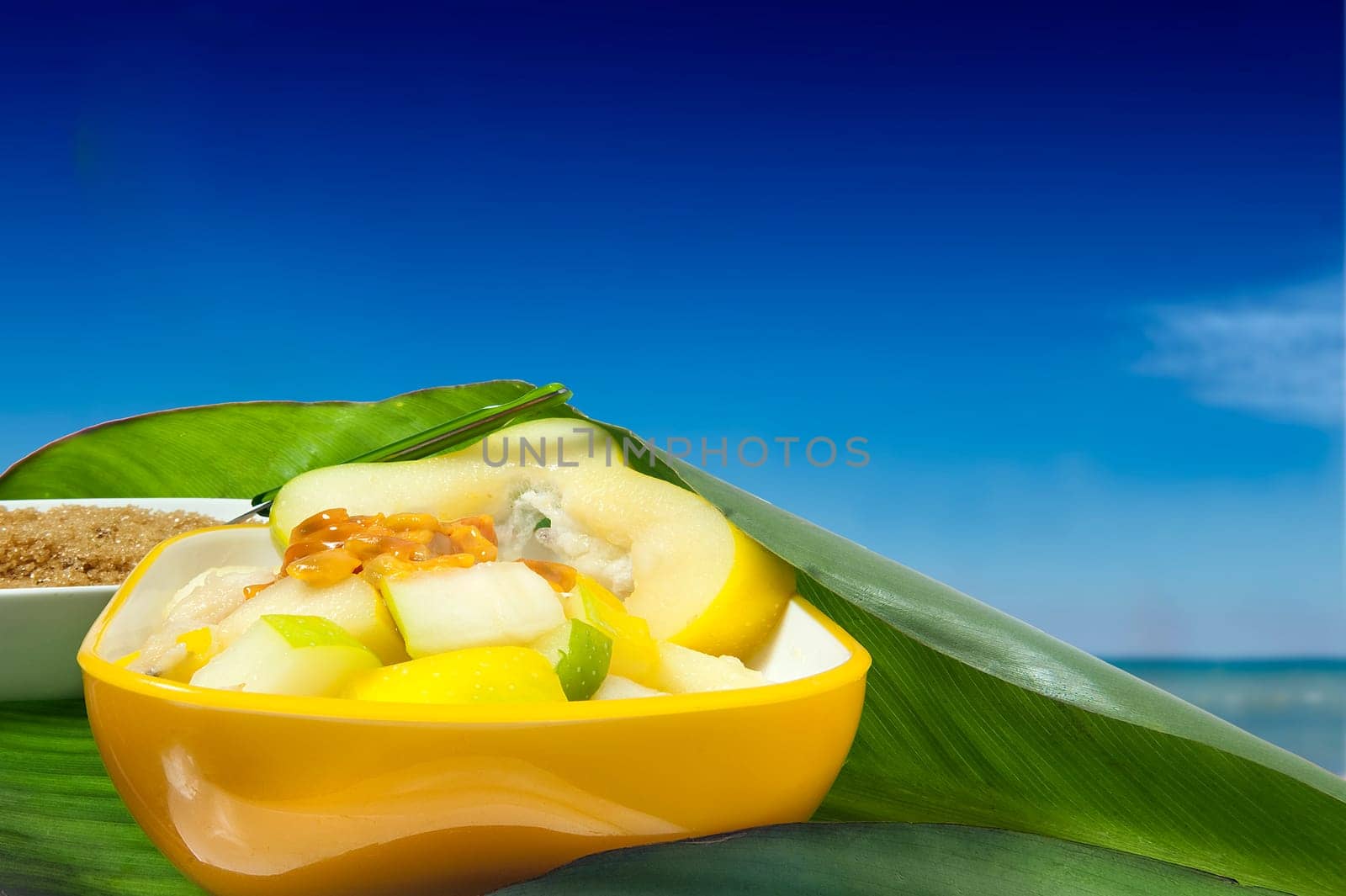a salad with tropical fruits along the tropical sea