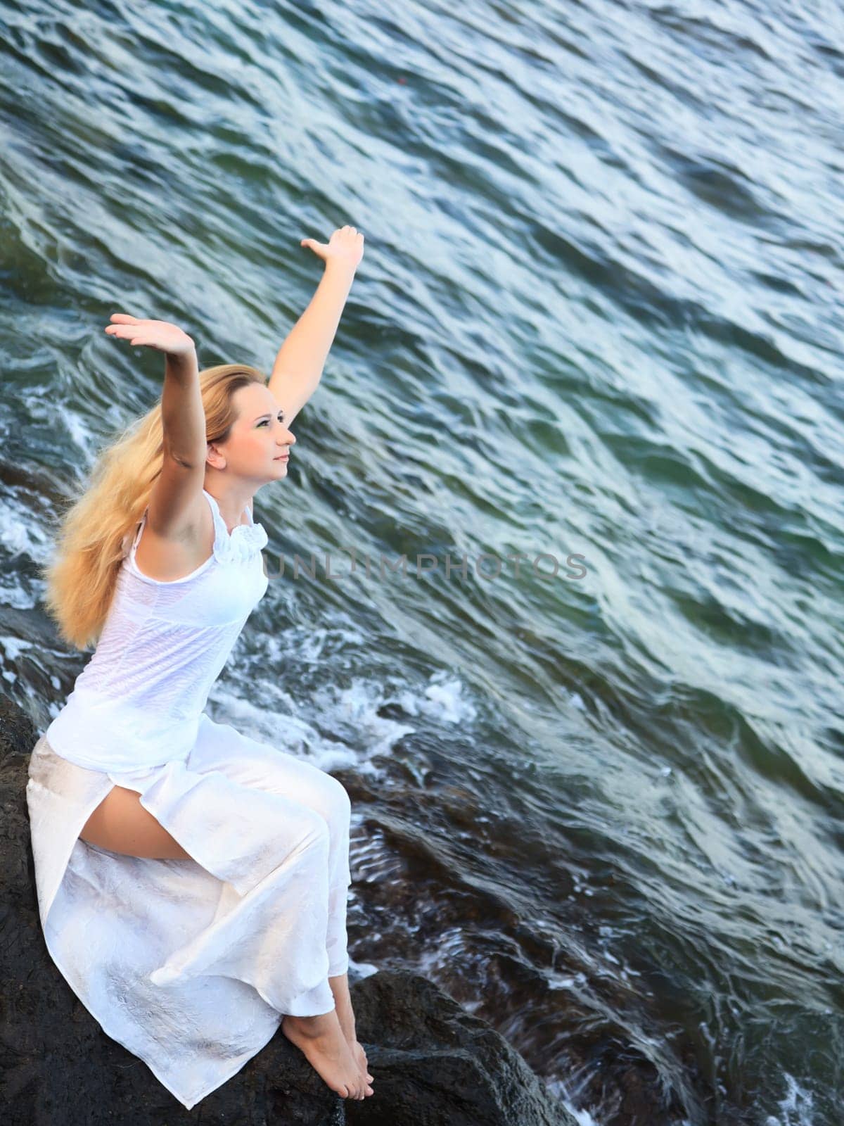 Young beautiful woman posing near the ocean