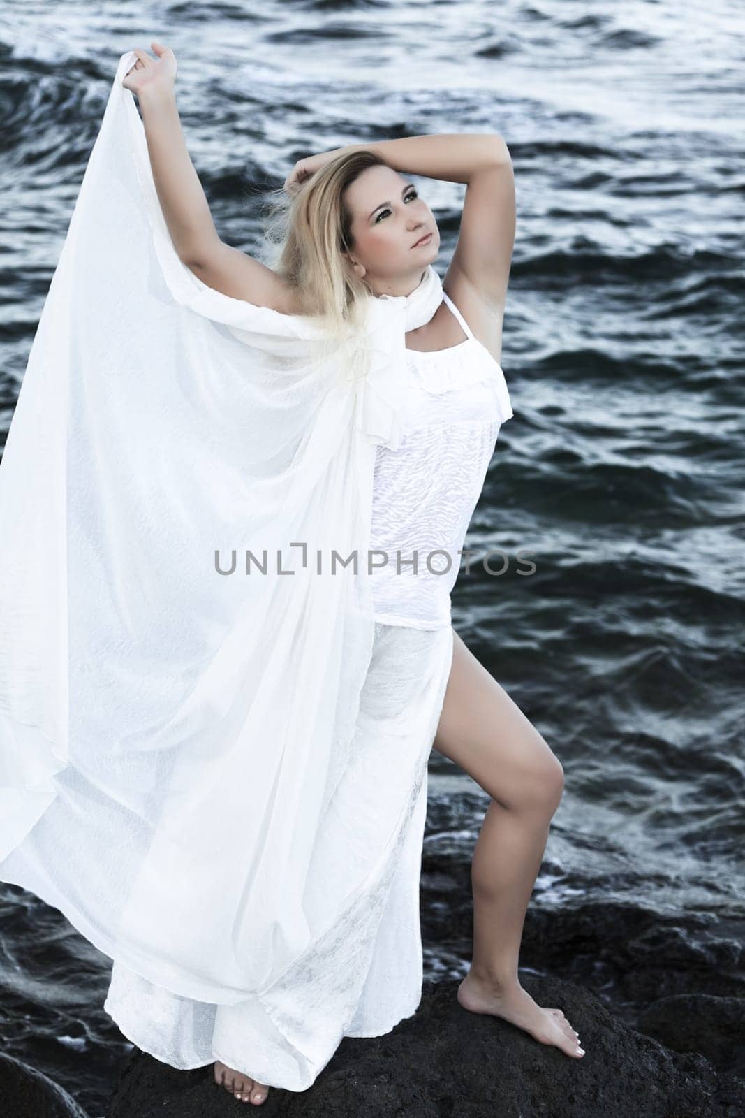 Young beautiful woman posing near the ocean