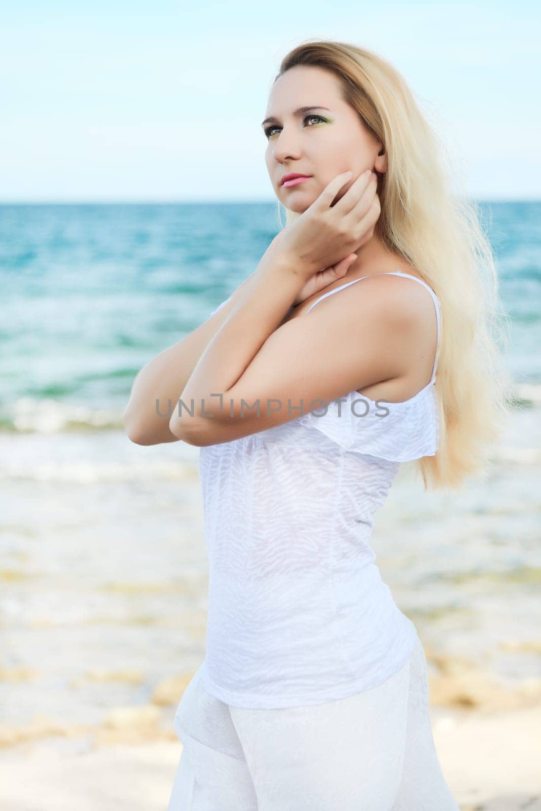 Young beautiful woman posing near the ocean