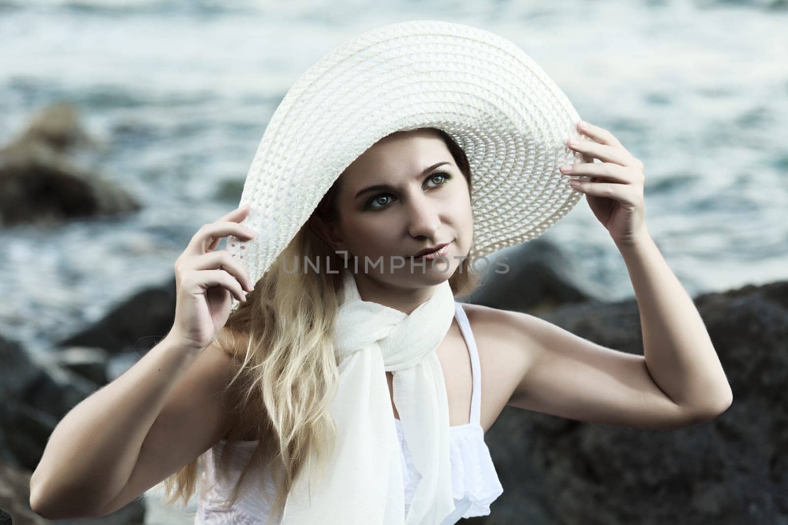 Young beautiful woman posing near the ocean