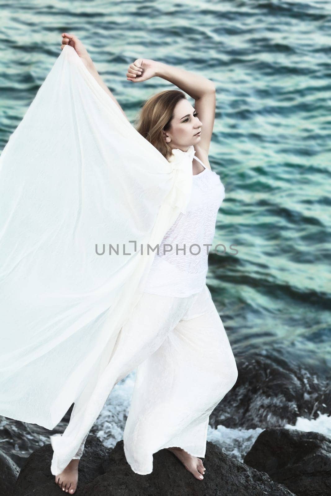 Young beautiful woman posing near the ocean