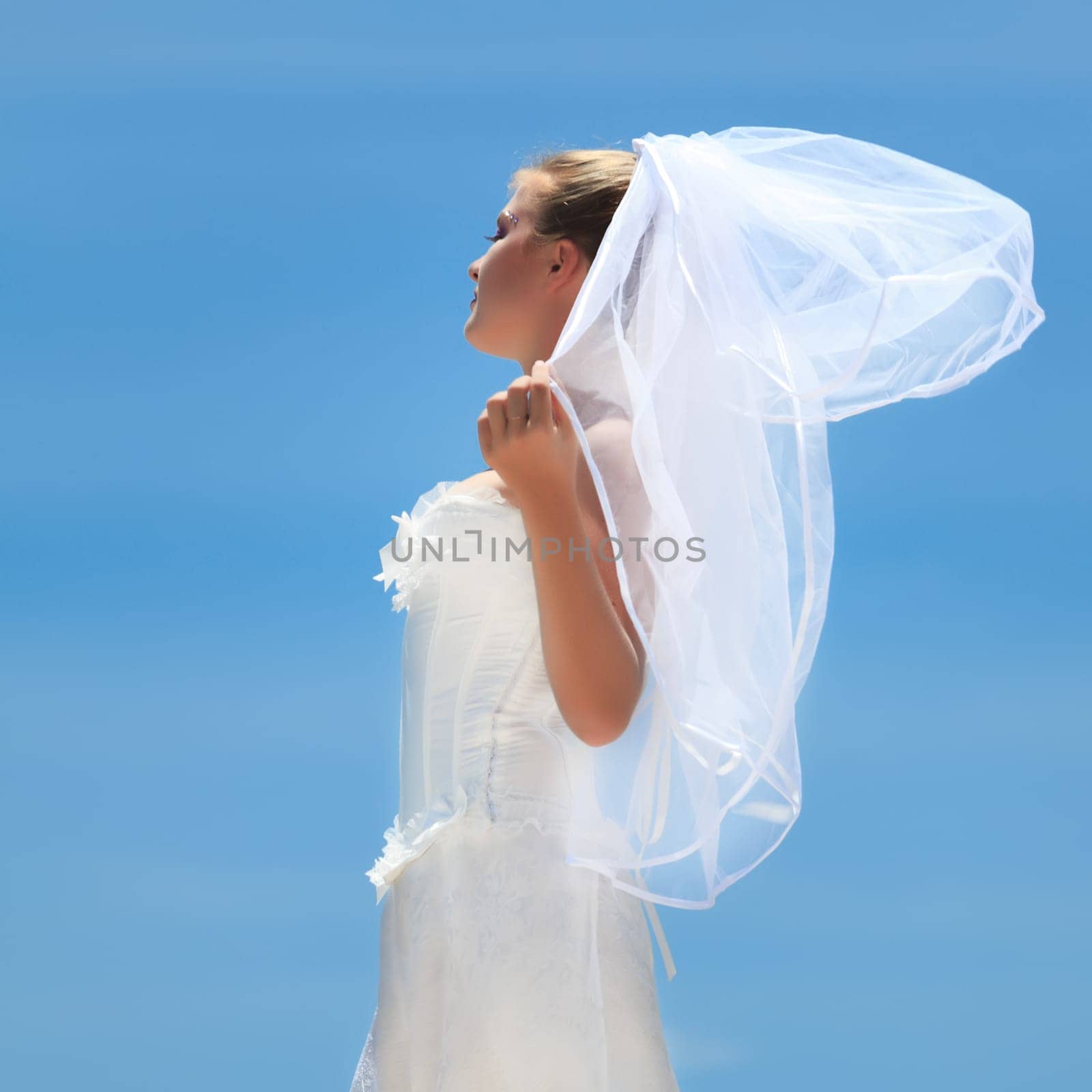 Beautiful young  bride on the blue sky background