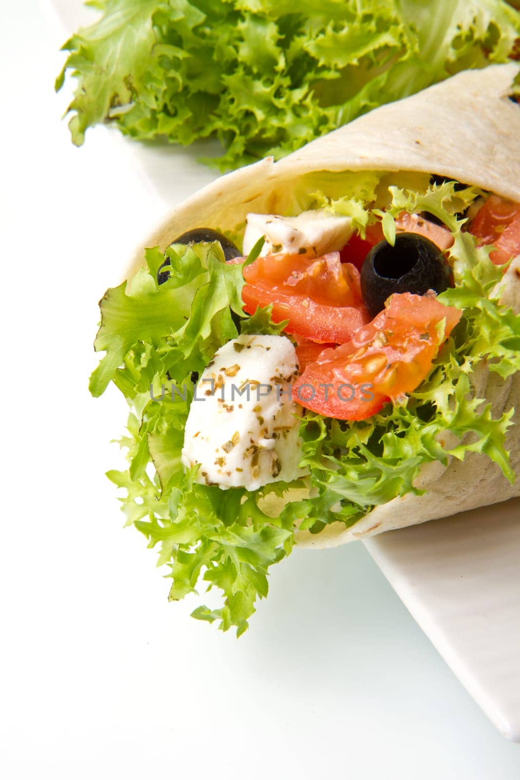 vegetarian piadina with fresh salad, tomatoes, olives and mozzarella cheese