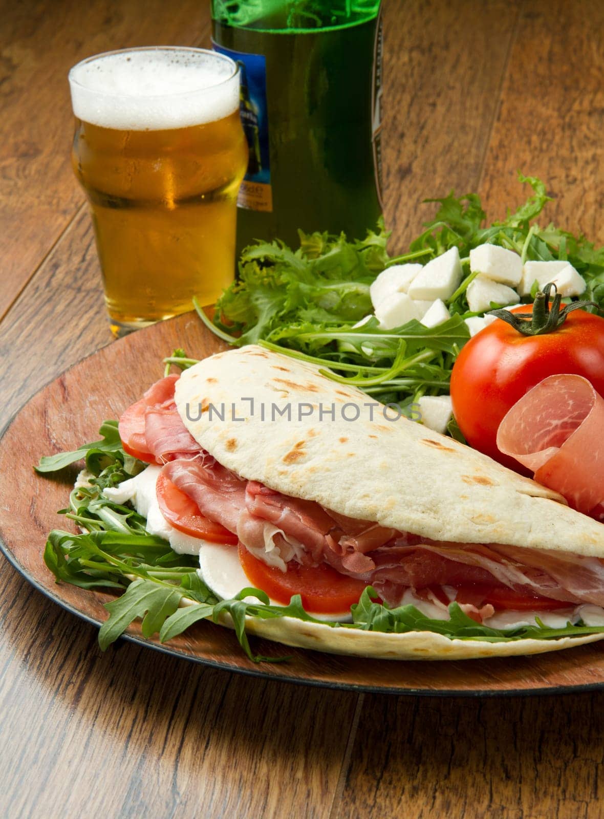 italian piadina with ham, fresh salad and mozzarella cheese