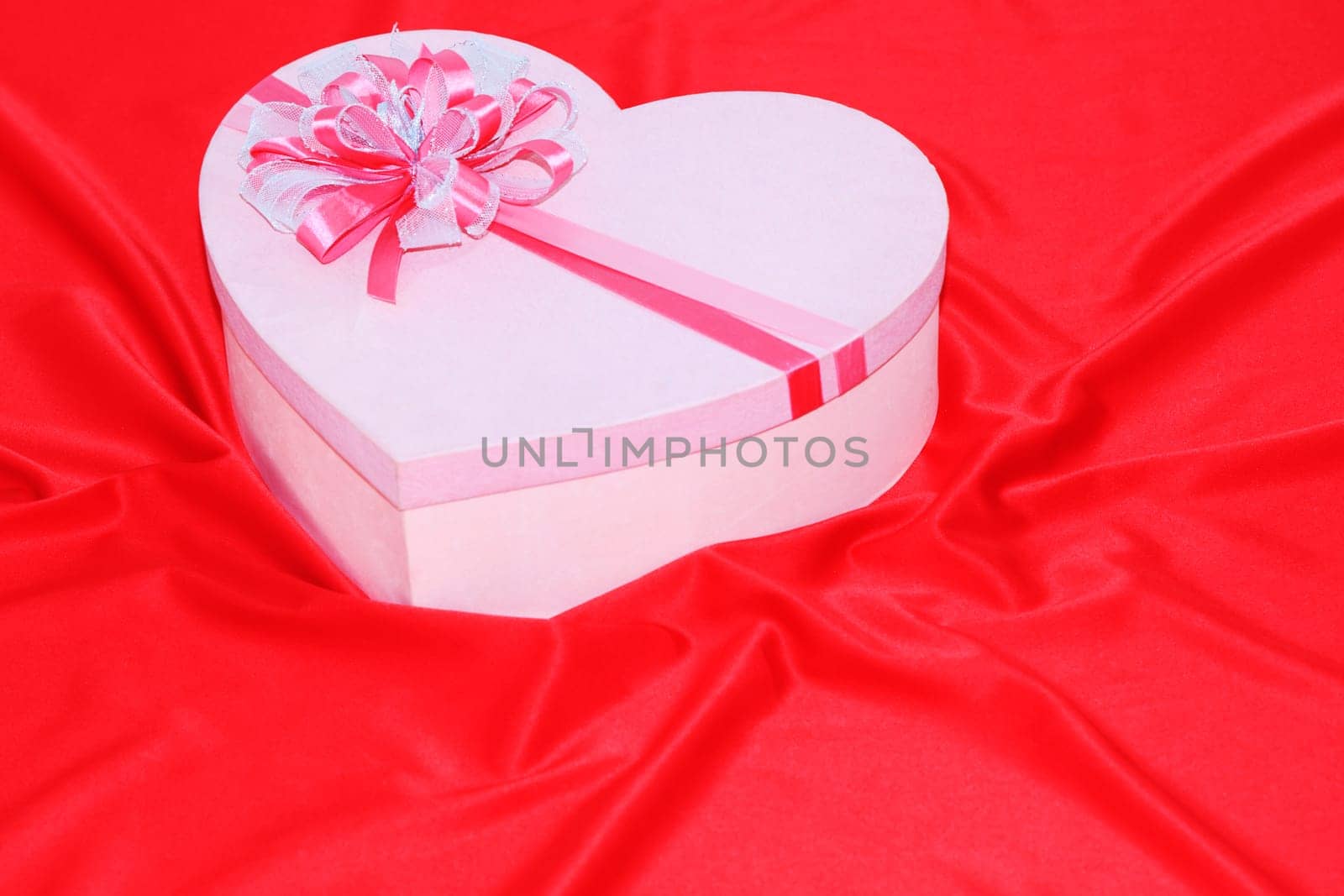 Gift box on the red silk background