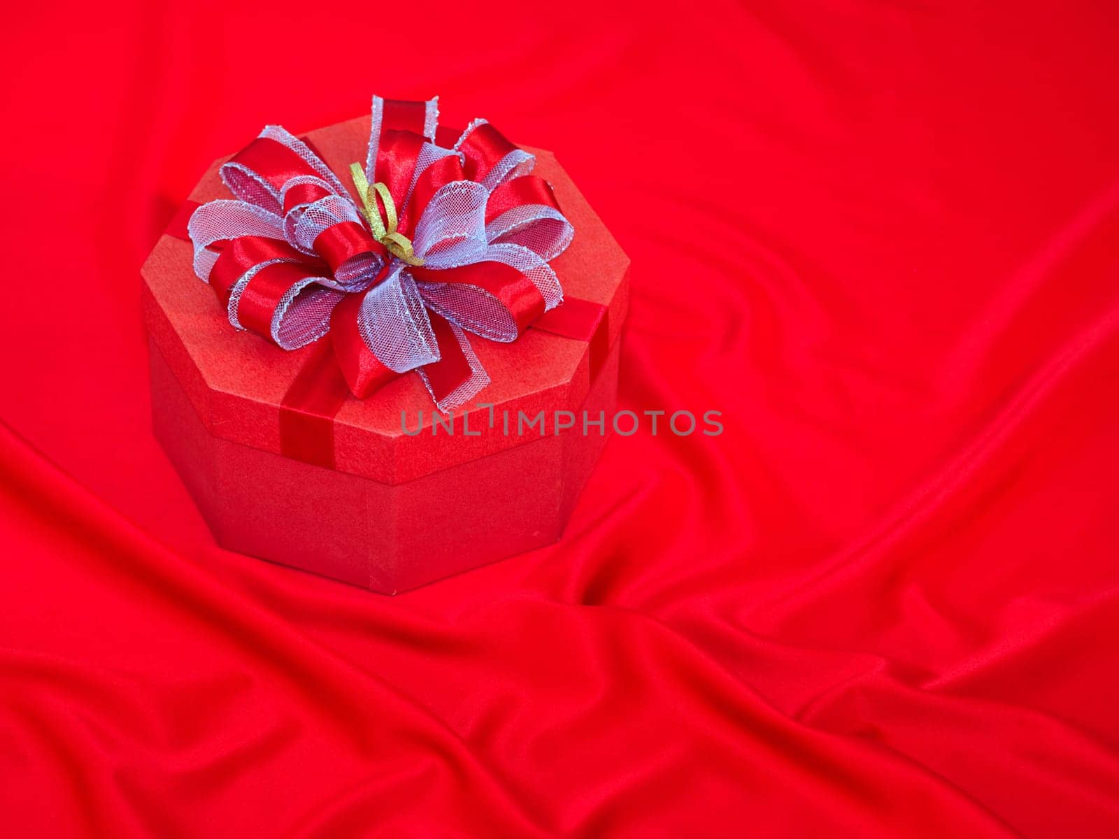 Gift box on the red silk background