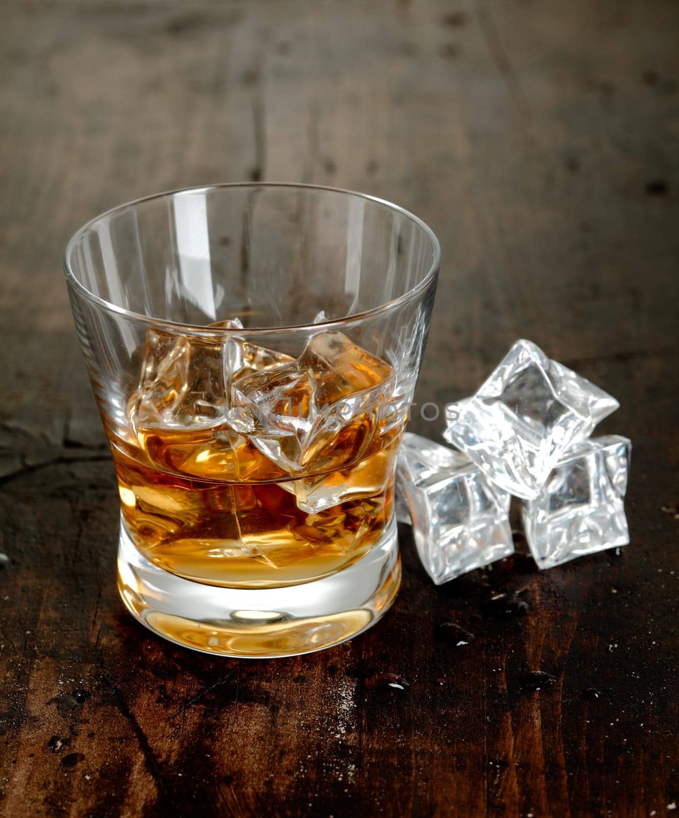 Scotch and Ice cubes on a wooden background