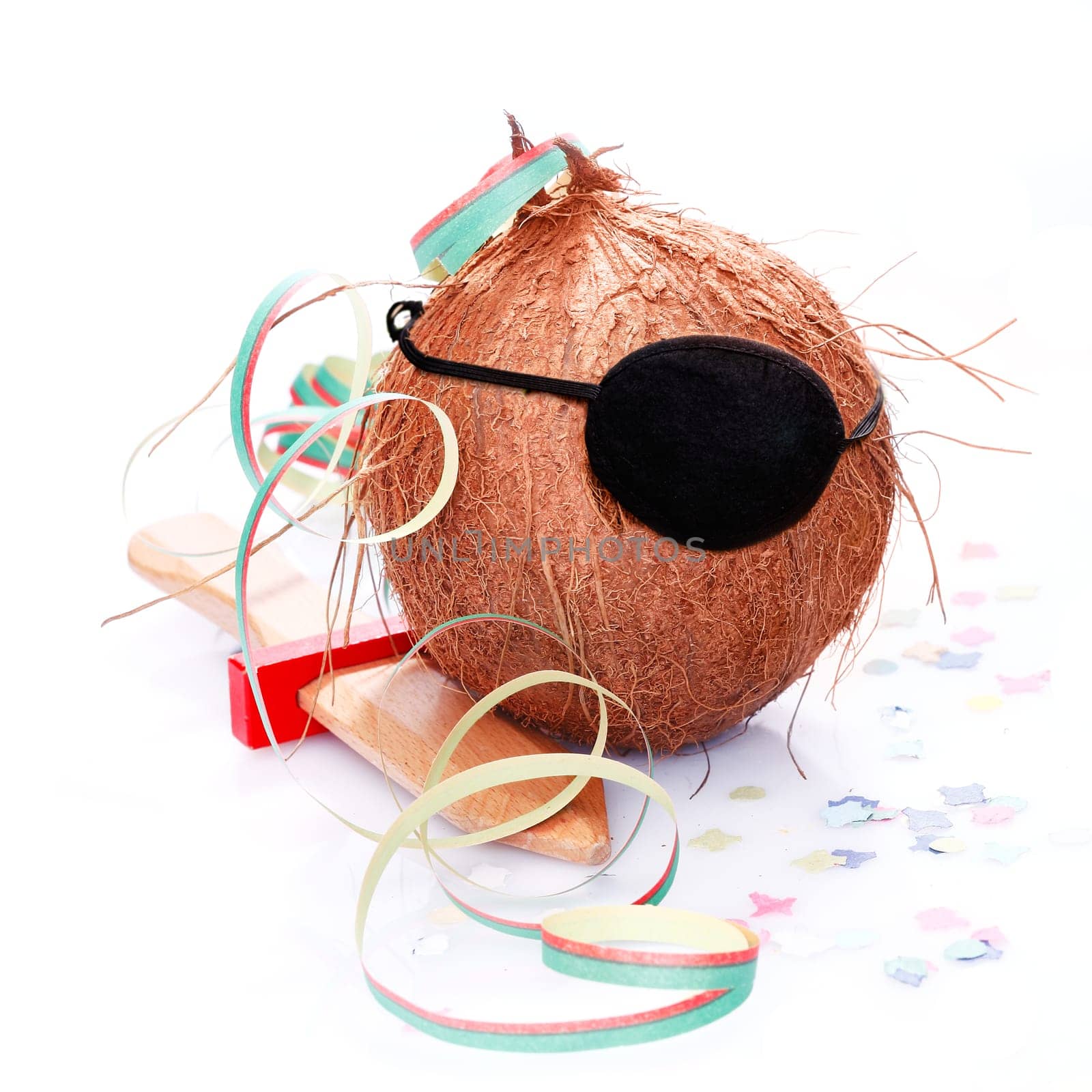 Coconut with an eye patch, confetti and a paper streamer. For little Pirates and caribbean and tropical concepts.