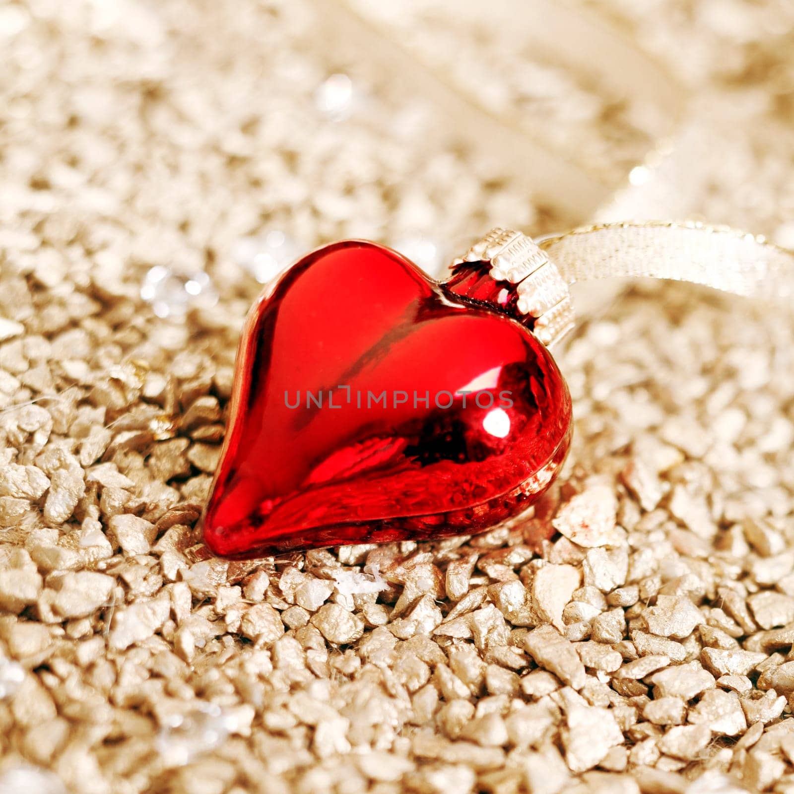 Romantic background of a shiny red Christmas heart ornament with shallow dof
