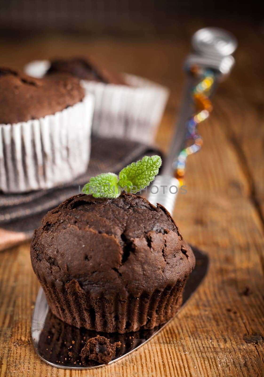 Delicious freshly baked muffin garnished with mint served on a metal spatula