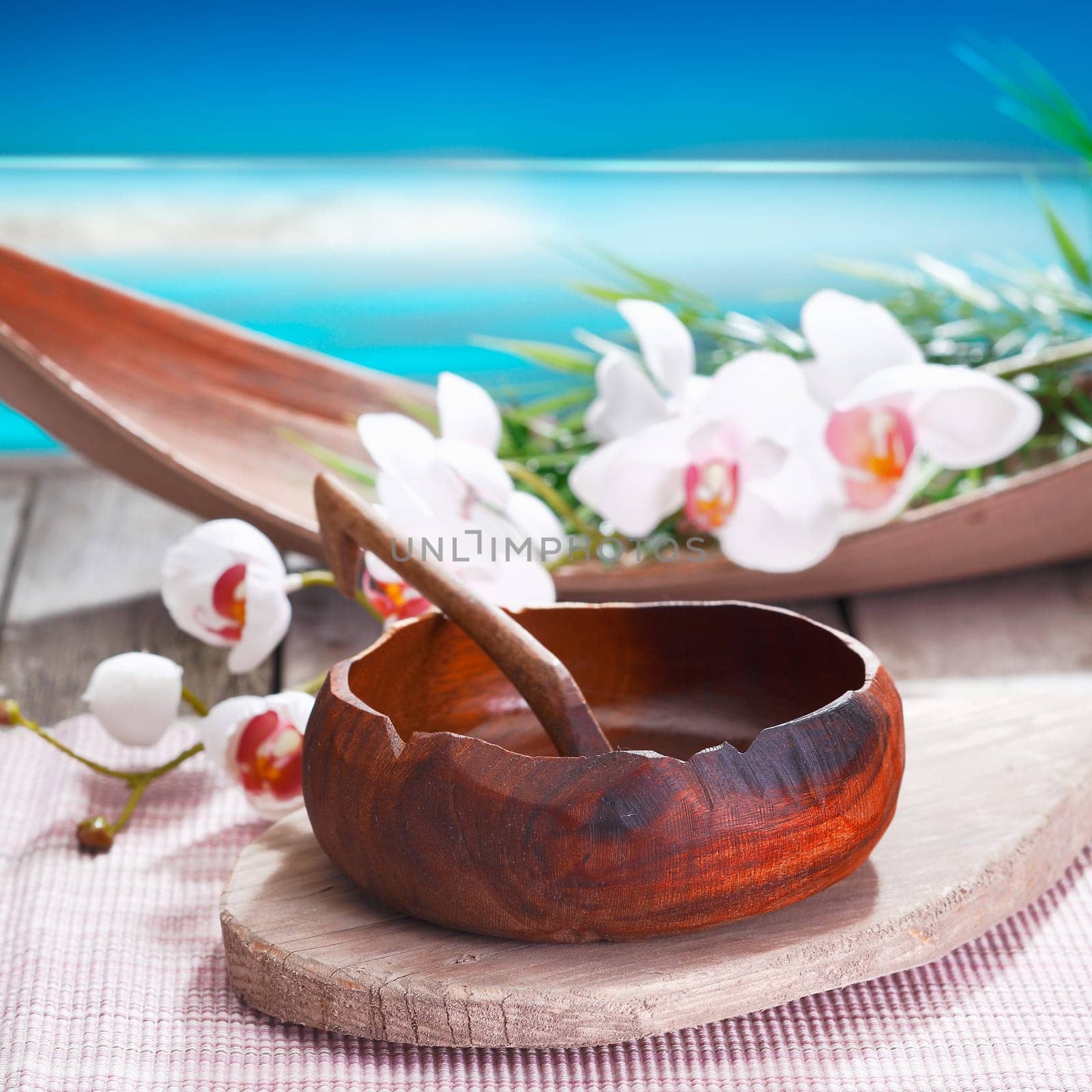Exotic white orchids and an ethnic handcrafted bowl lend a different air to this spa treatment alongside the water