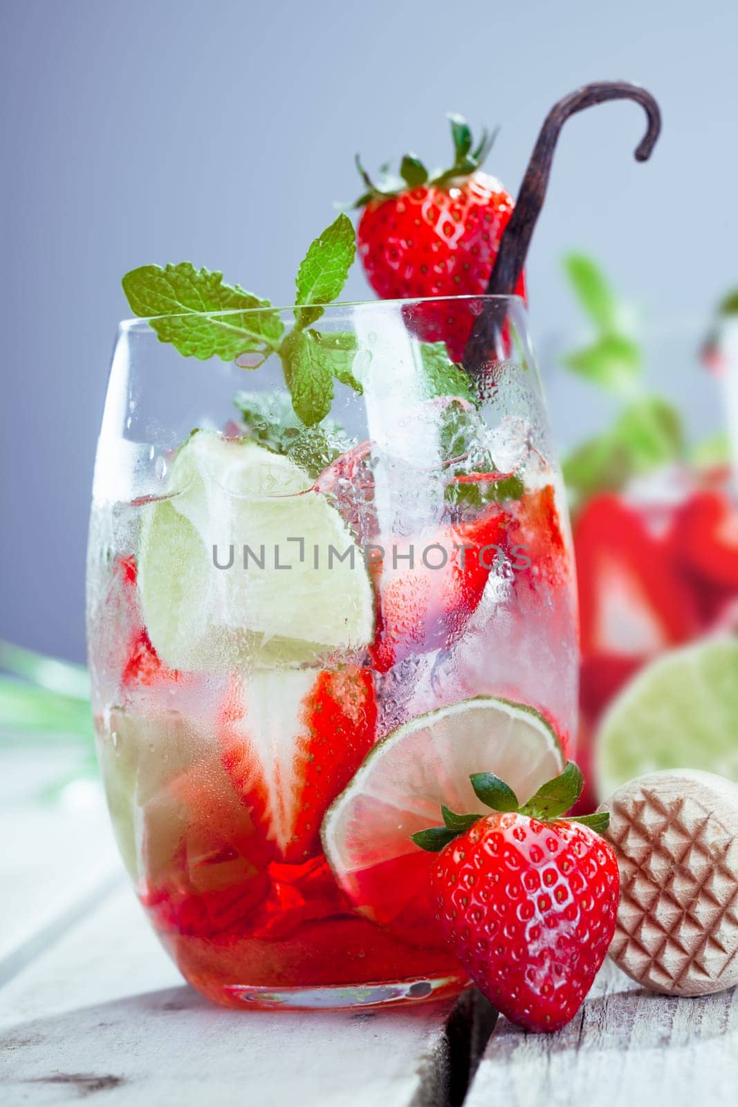 Glass of colourful cool ripe red strawberry and lemon cocktail with whole fresh fruit