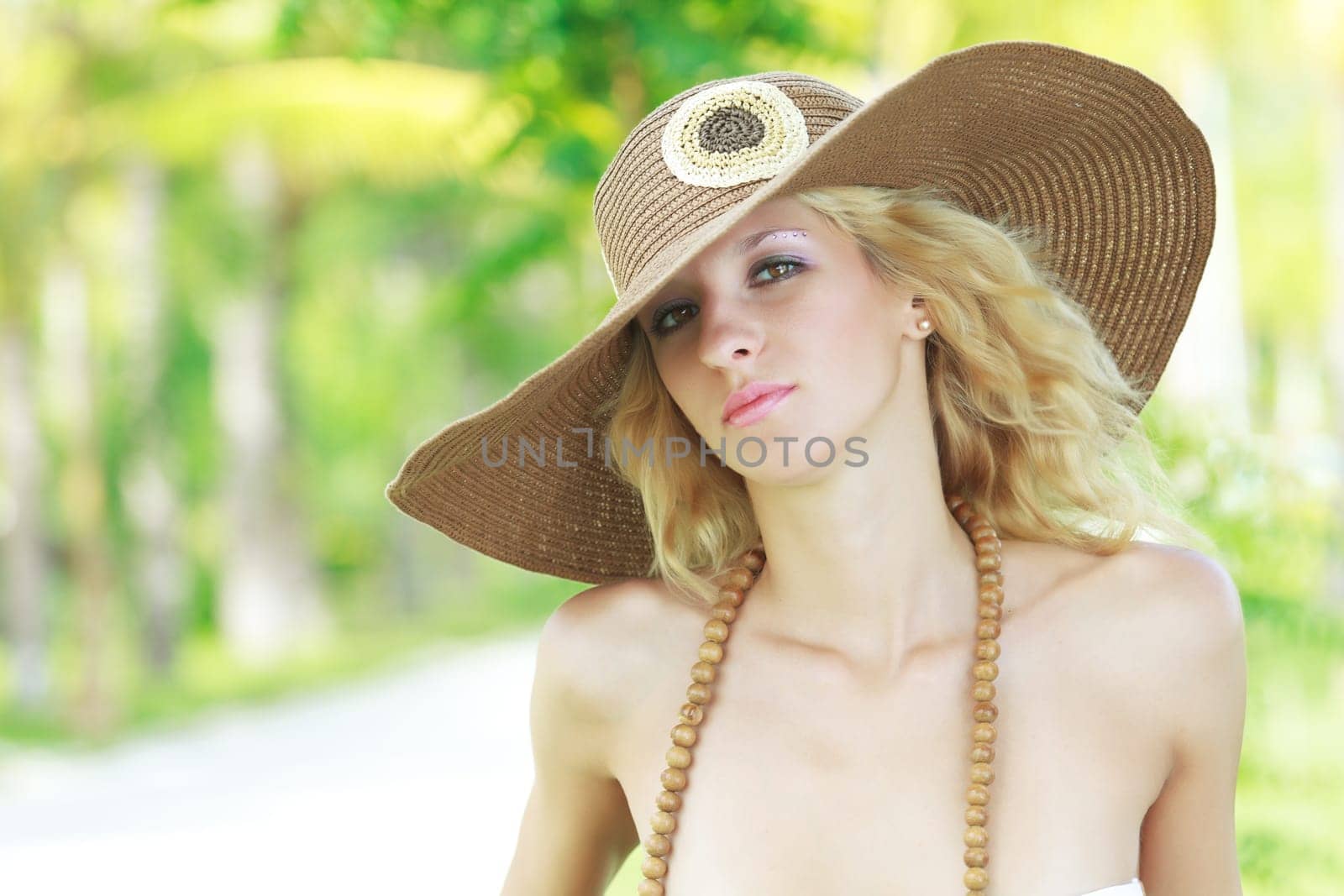 Outdoor portrait of a young beautiful woman in hat