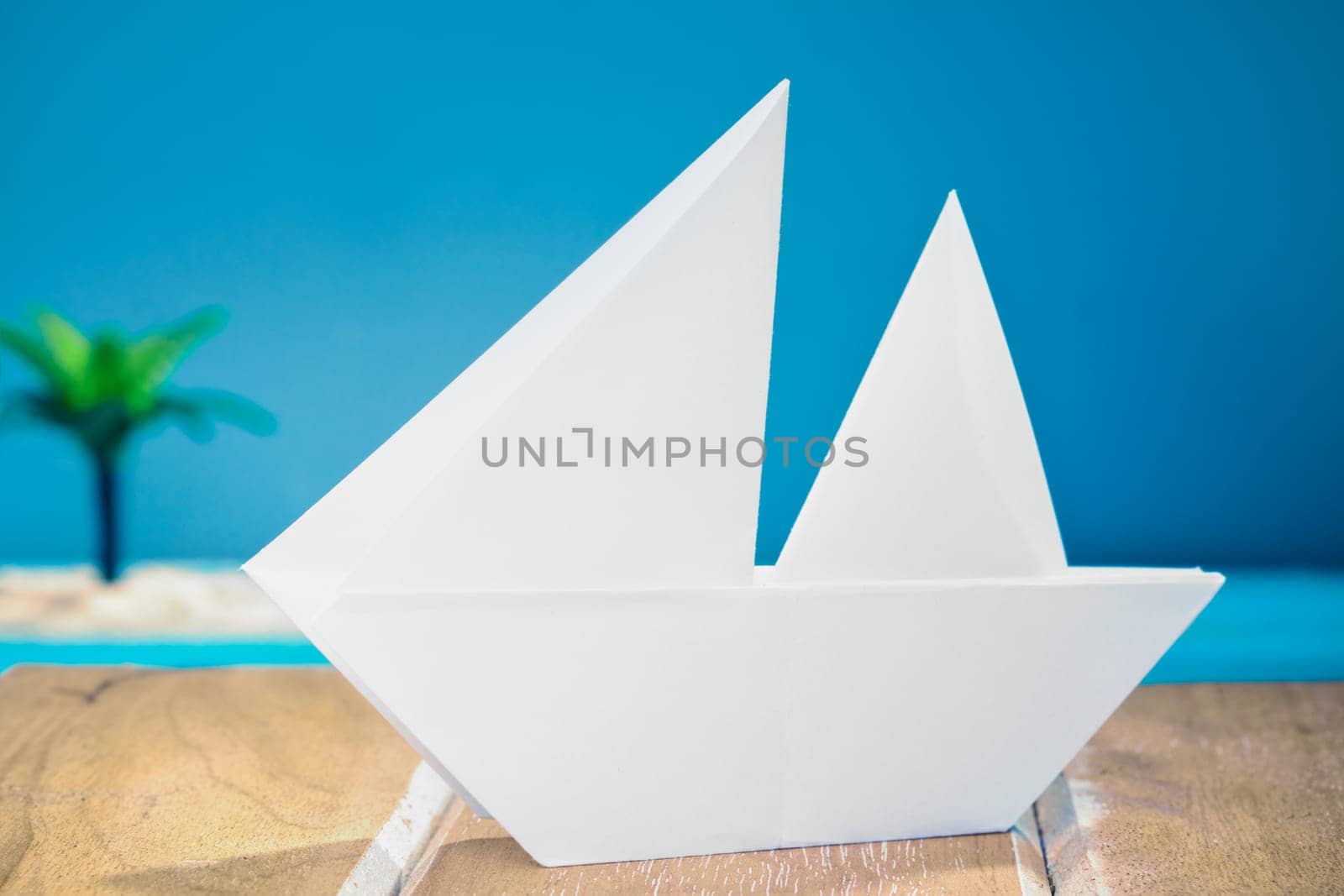 Paper Boat on a wooden deck at the sea.