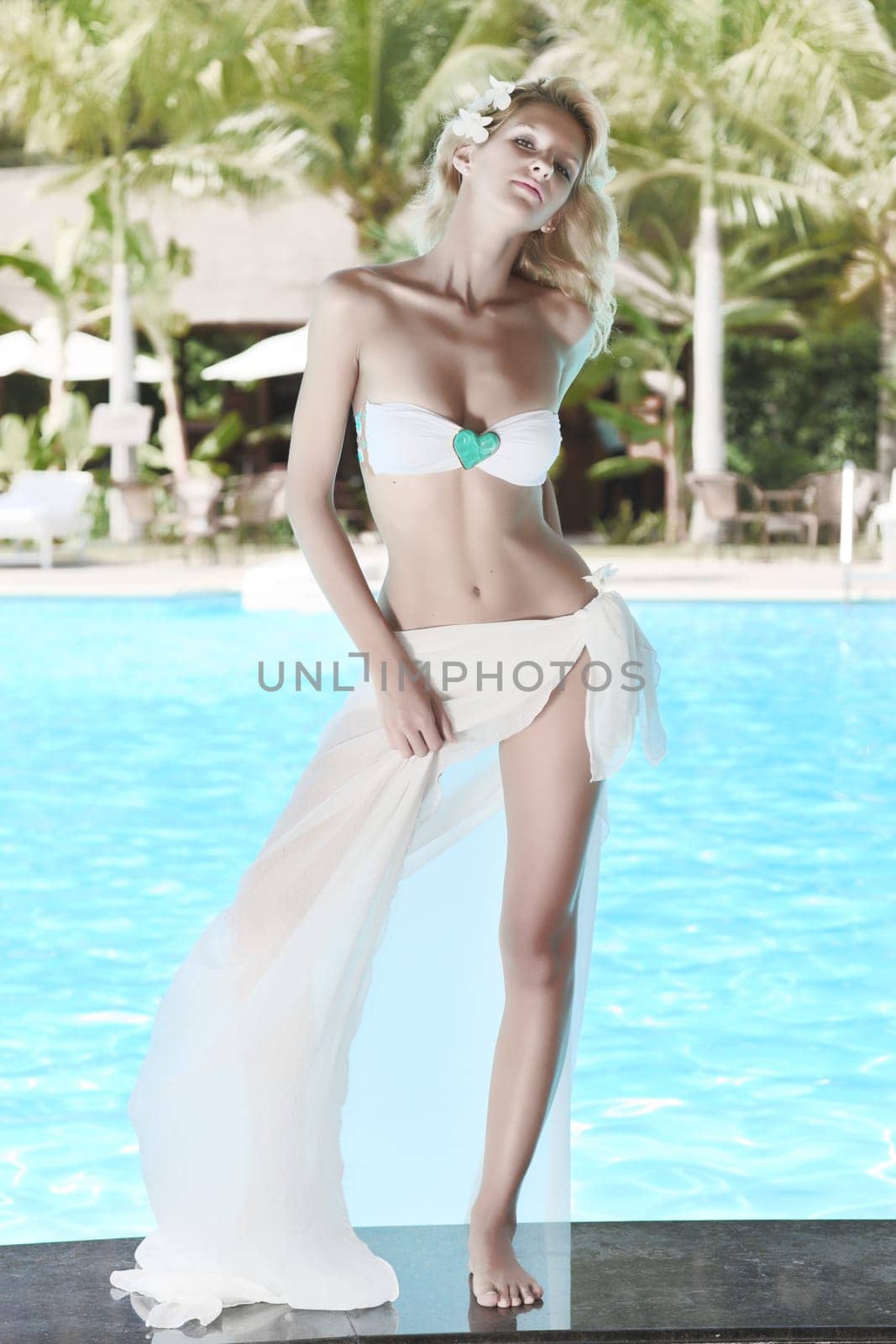 Young woman posing on the edge of swimming pool