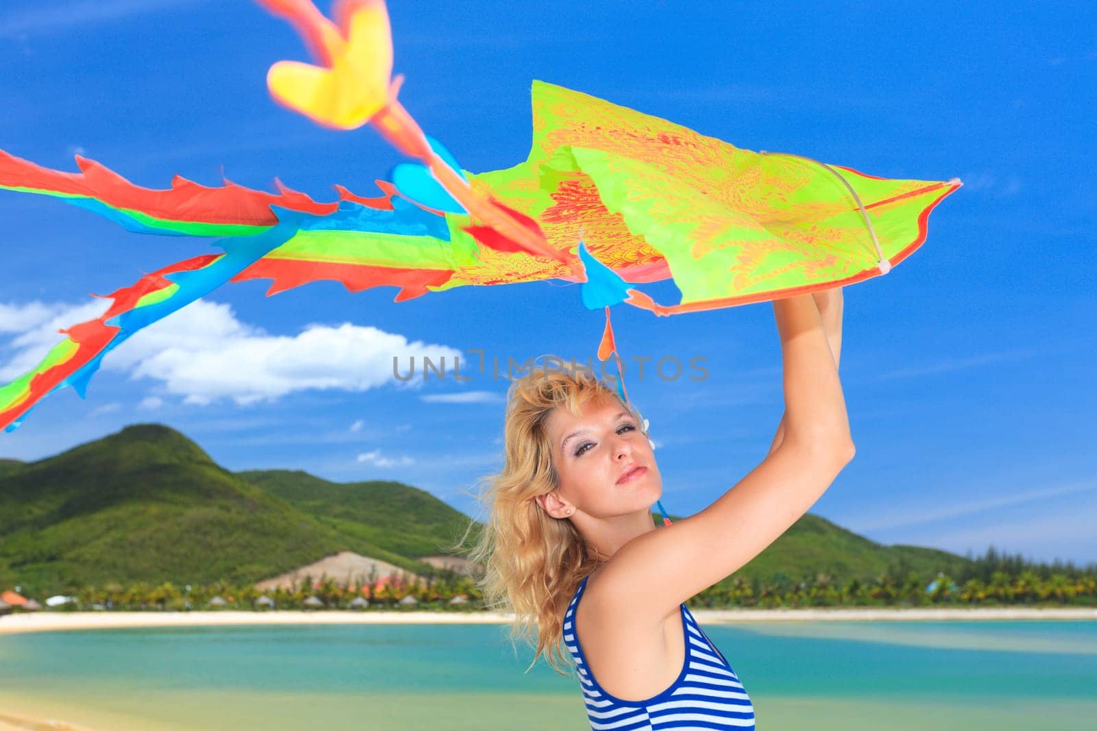 Young woman with kite on the beach