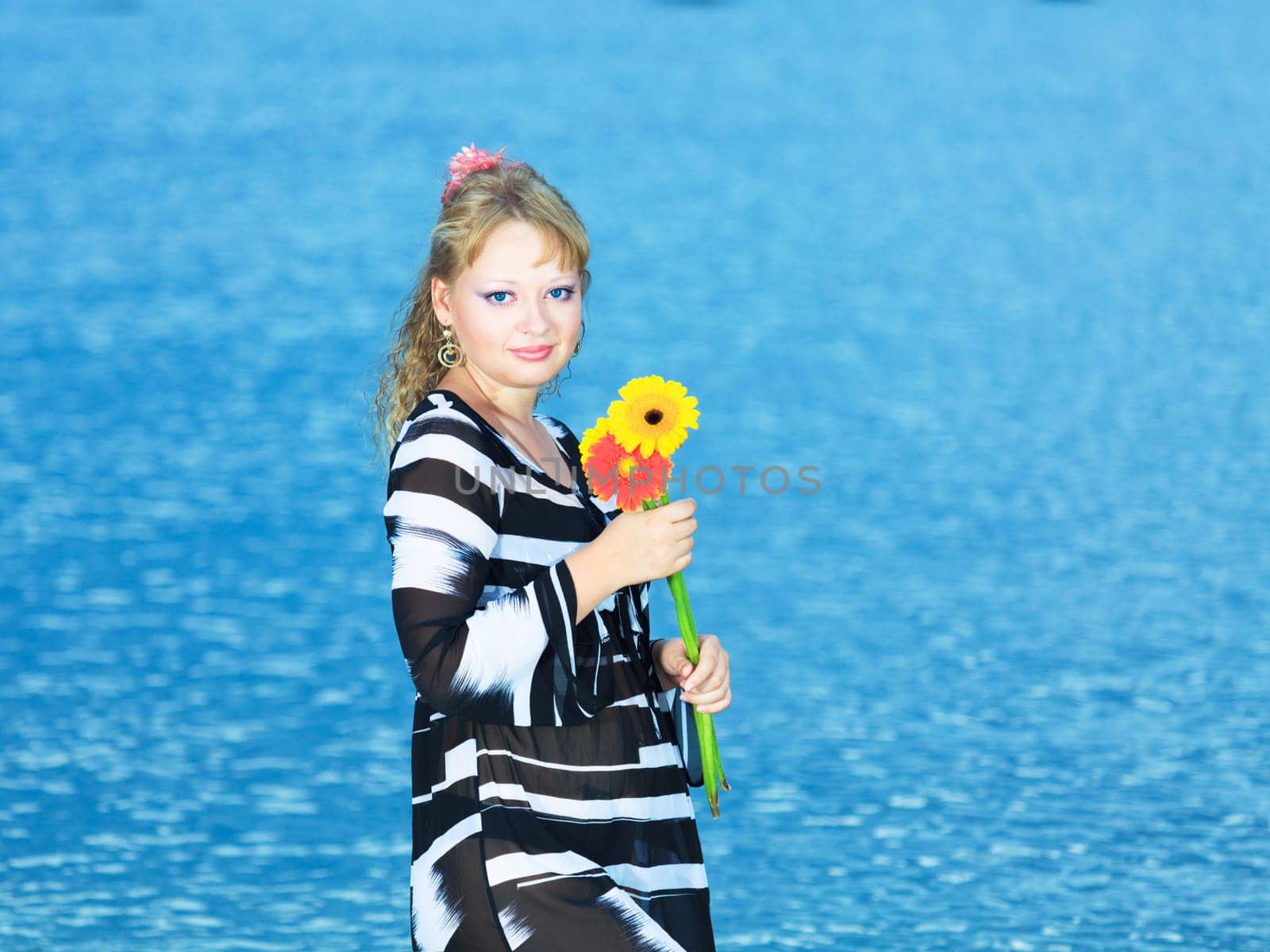 Beautiful woman with flowers in the sea