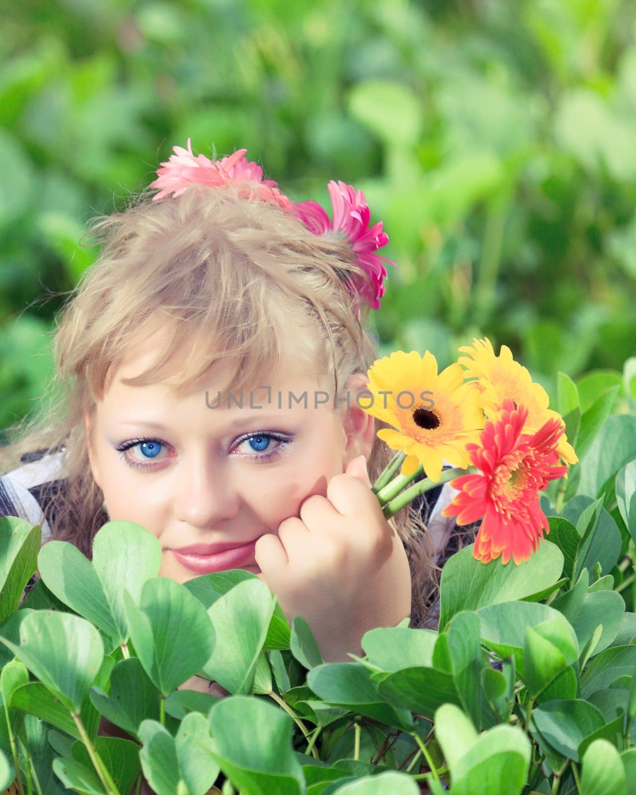 Beautiful woman in grass with gerbera flowers